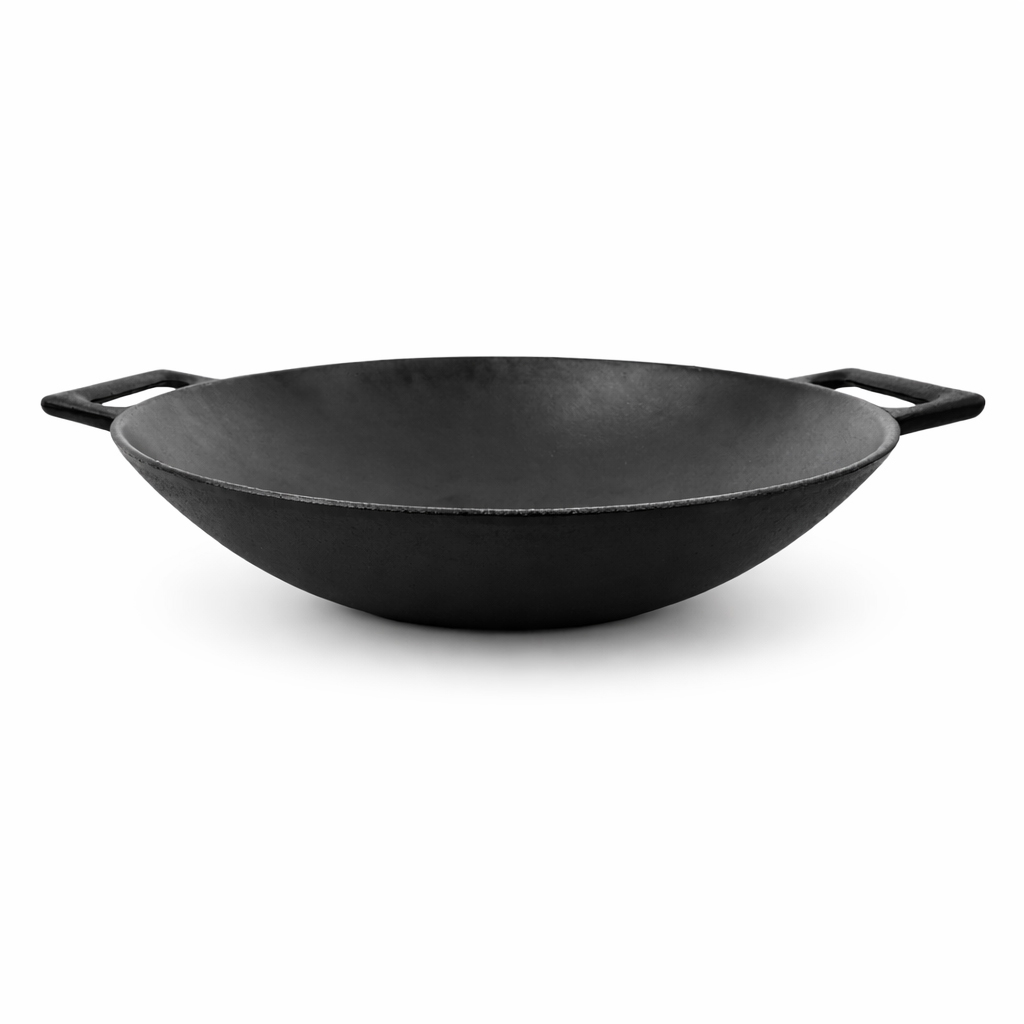 A black cast iron wok with two handles sits against a white background.