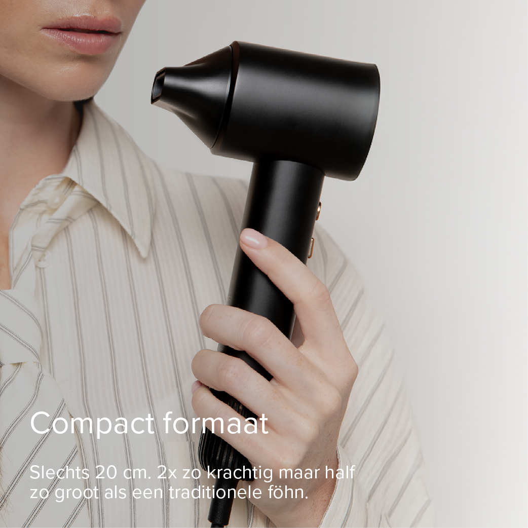 A person holds a compact black hairdryer. Striped shirt.