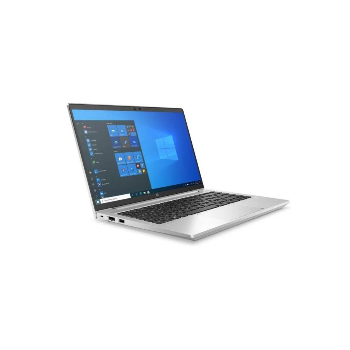 Un portátil plateado con pantalla azul de Windows, sobre una superficie blanca.