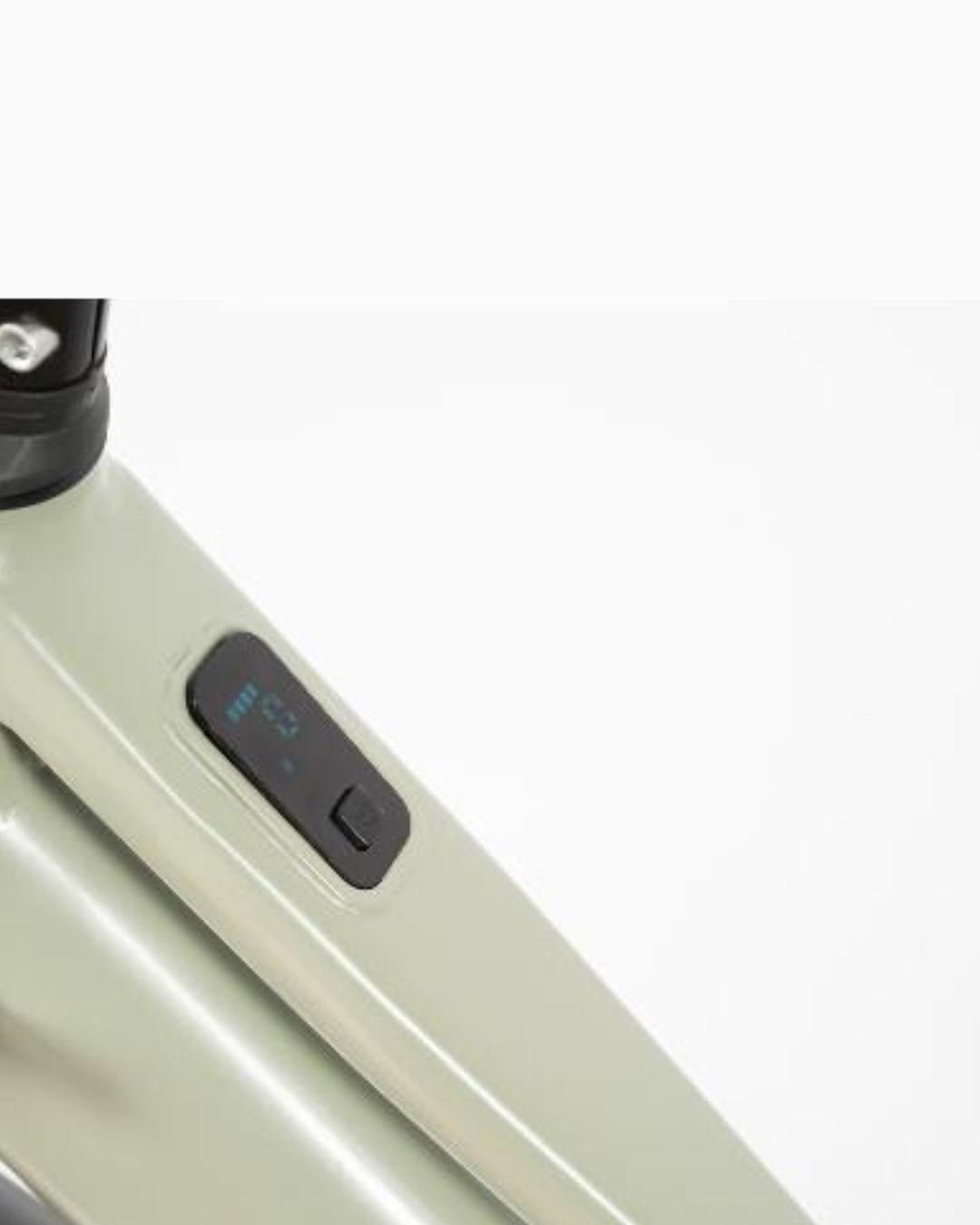 Primo piano di un telaio di bicicletta verde chiaro con display digitale e pulsante.