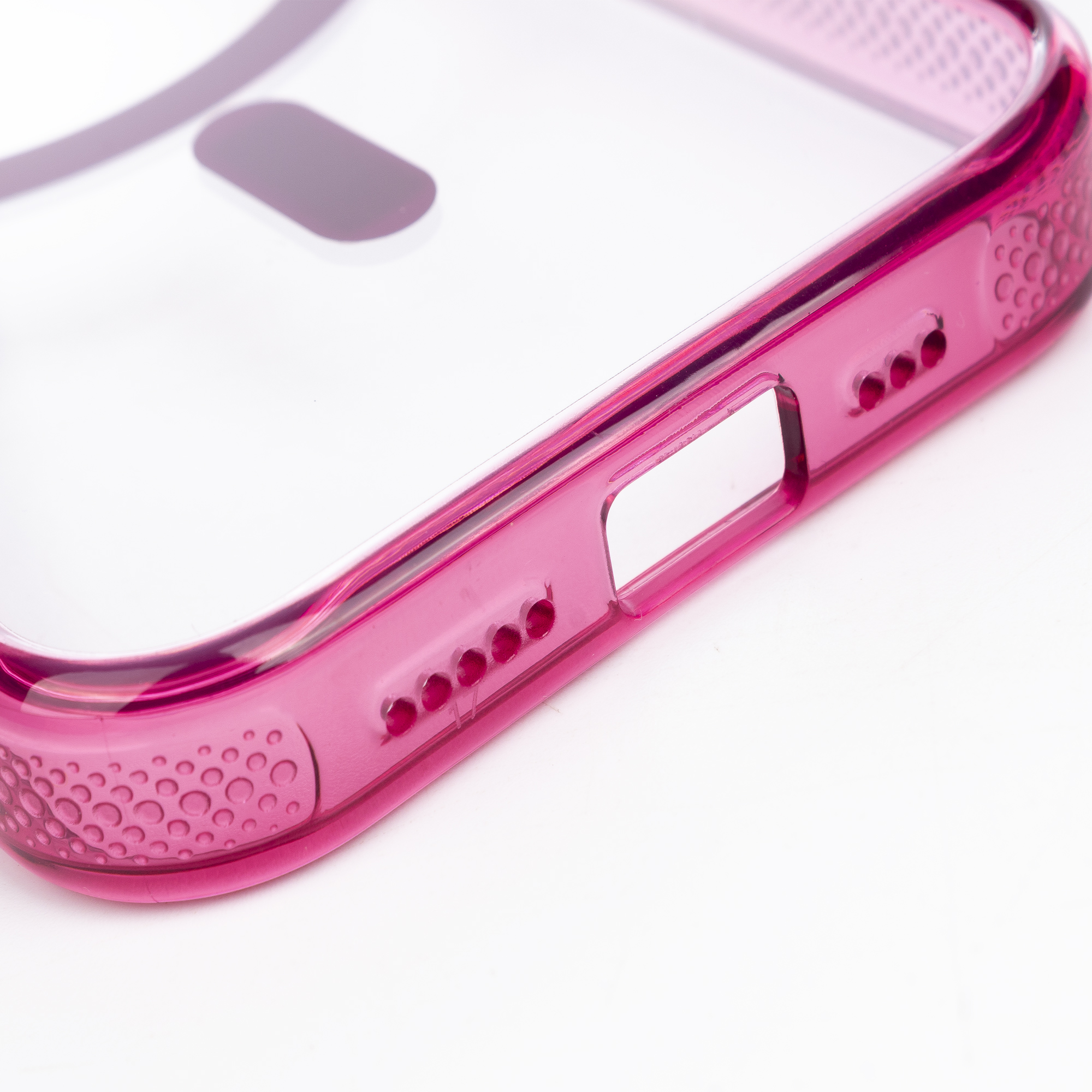 Una cover per telefono rosa e trasparente con motivo a pois su sfondo bianco.