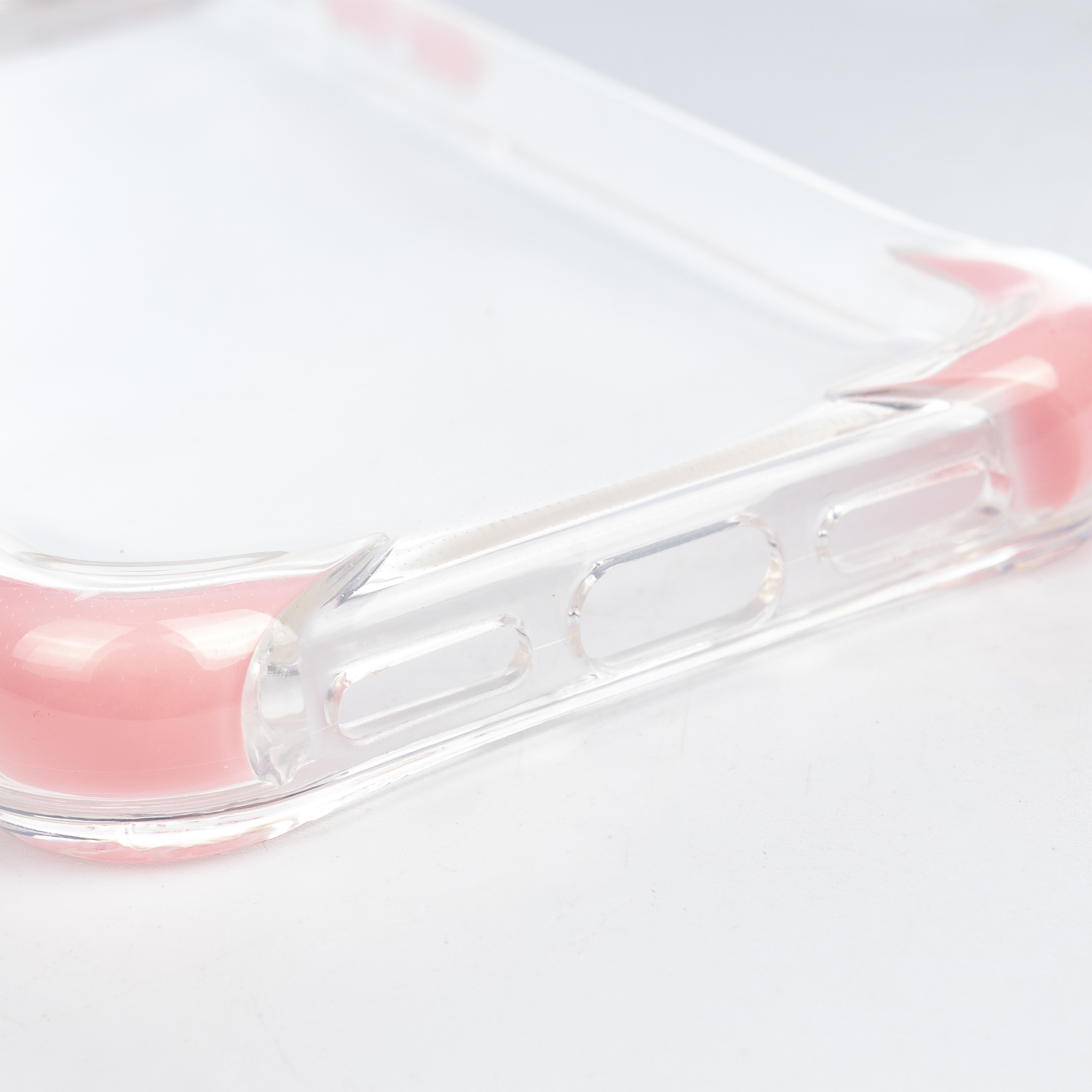 Una cover trasparente per telefono con accenti rosa e pulsanti.