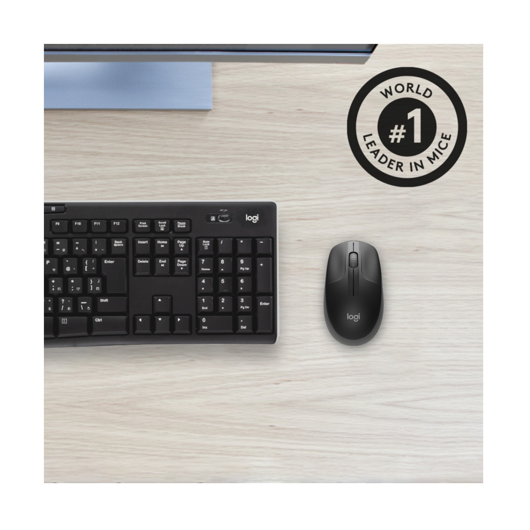 Tastiera e mouse Logitech neri su scrivania in legno chiaro con logo.