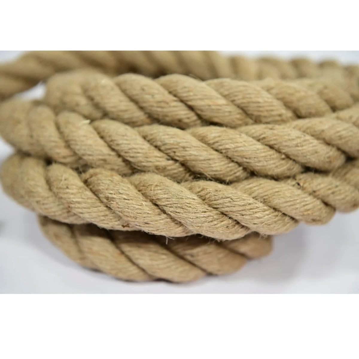 A thick, twisted rope made of natural fiber lies on a white background.