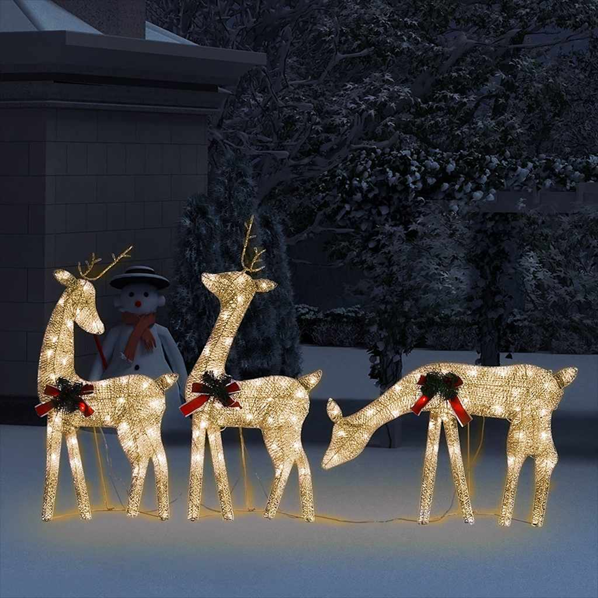 Drei beleuchtete Rentierfiguren mit roten Schleifen und Schneemann im Hintergrund.