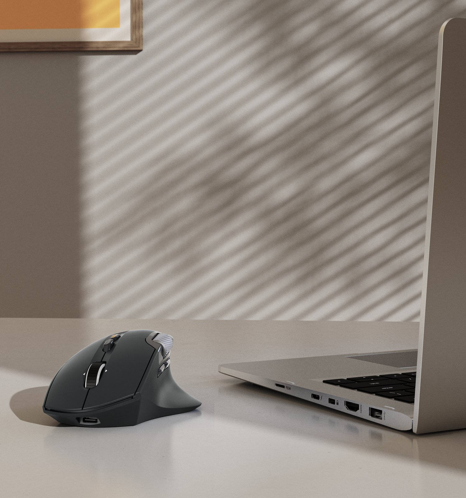 Un mouse scuro e un laptop su una scrivania. La luce filtra dalle persiane.