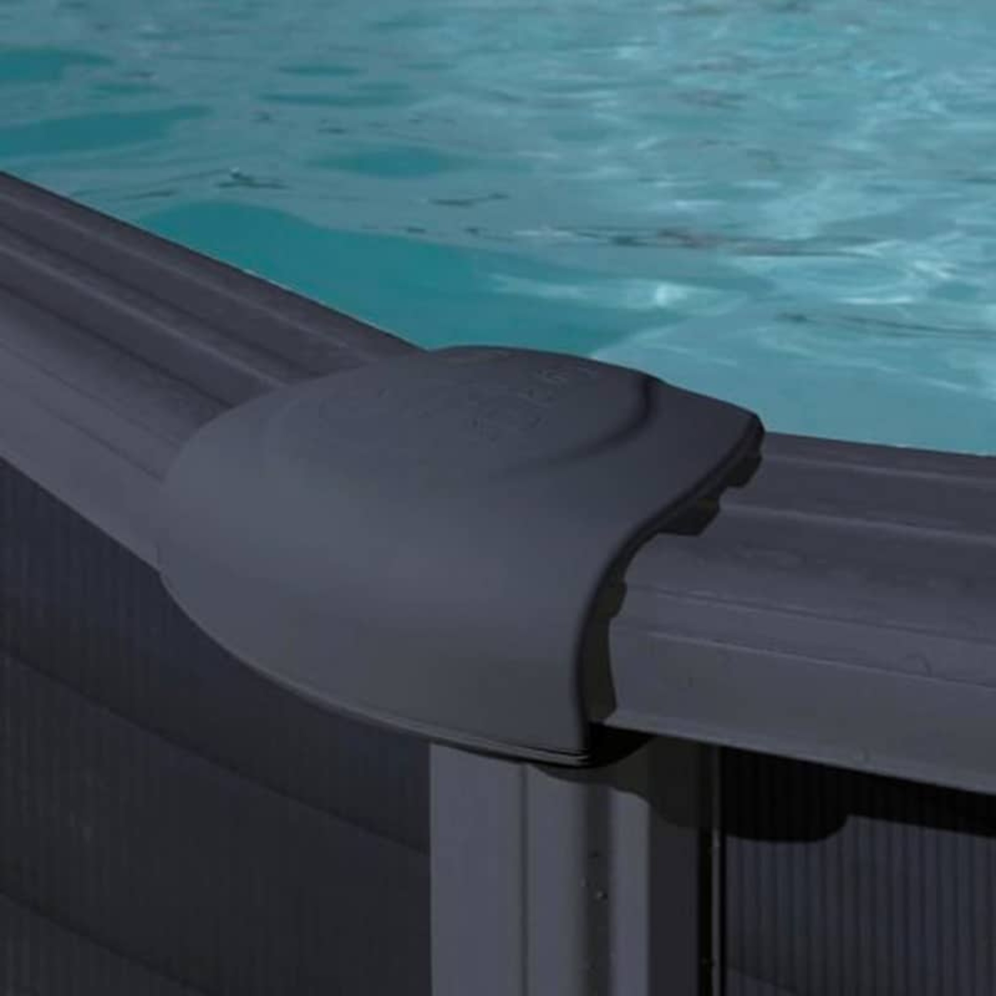 Primer plano de la pared de una piscina con una junta en esquina y agua azul.