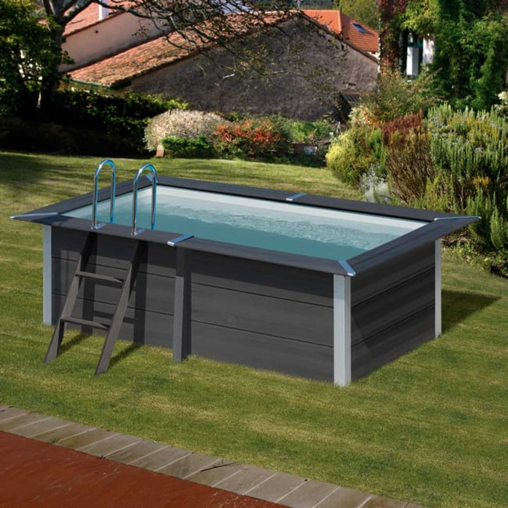 Una piscina rectangular con lados oscuros y una escalera se asienta sobre un césped verde.