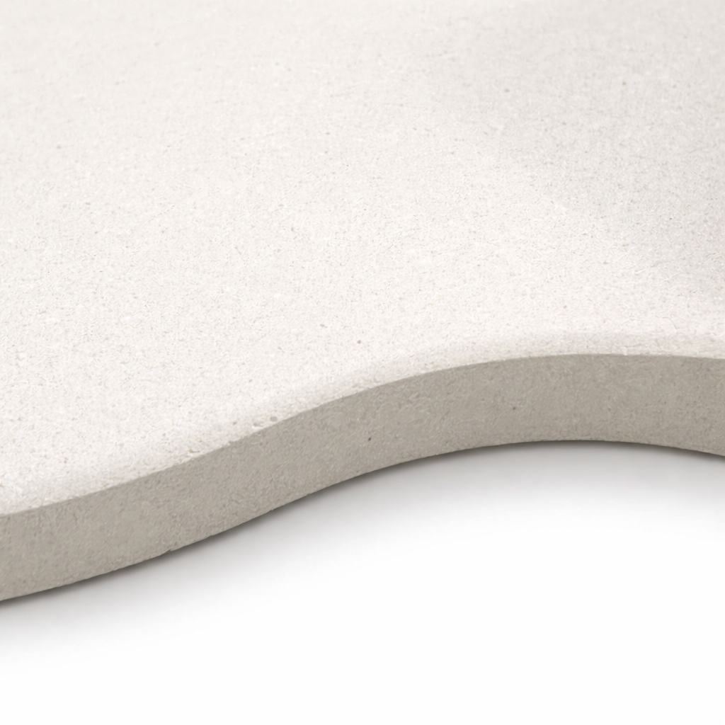 A close-up of a light gray, wavy-edged slab with a textured surface.