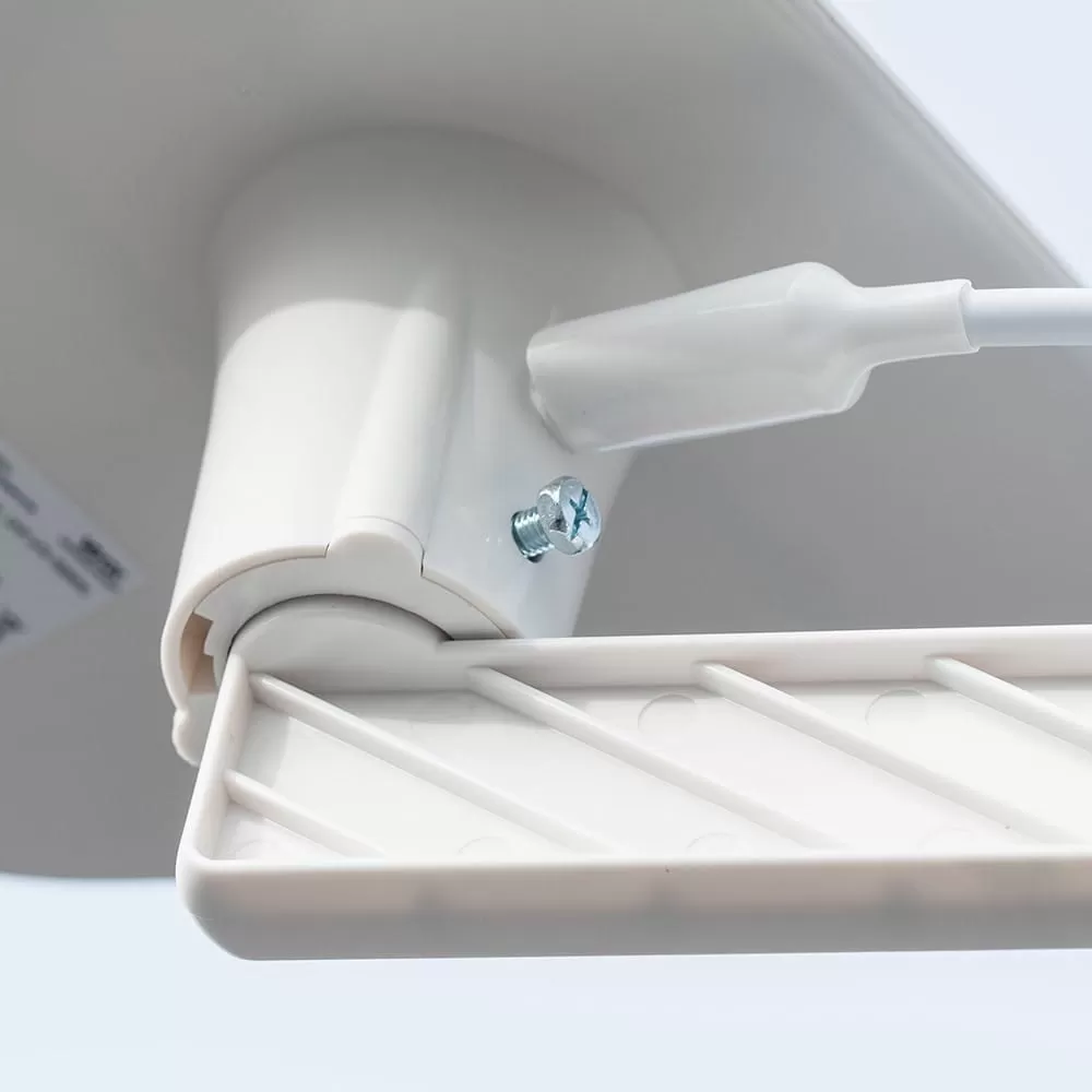 Zbliżenie srebrnej śruby mocującej białą plastikową część do urządzenia.