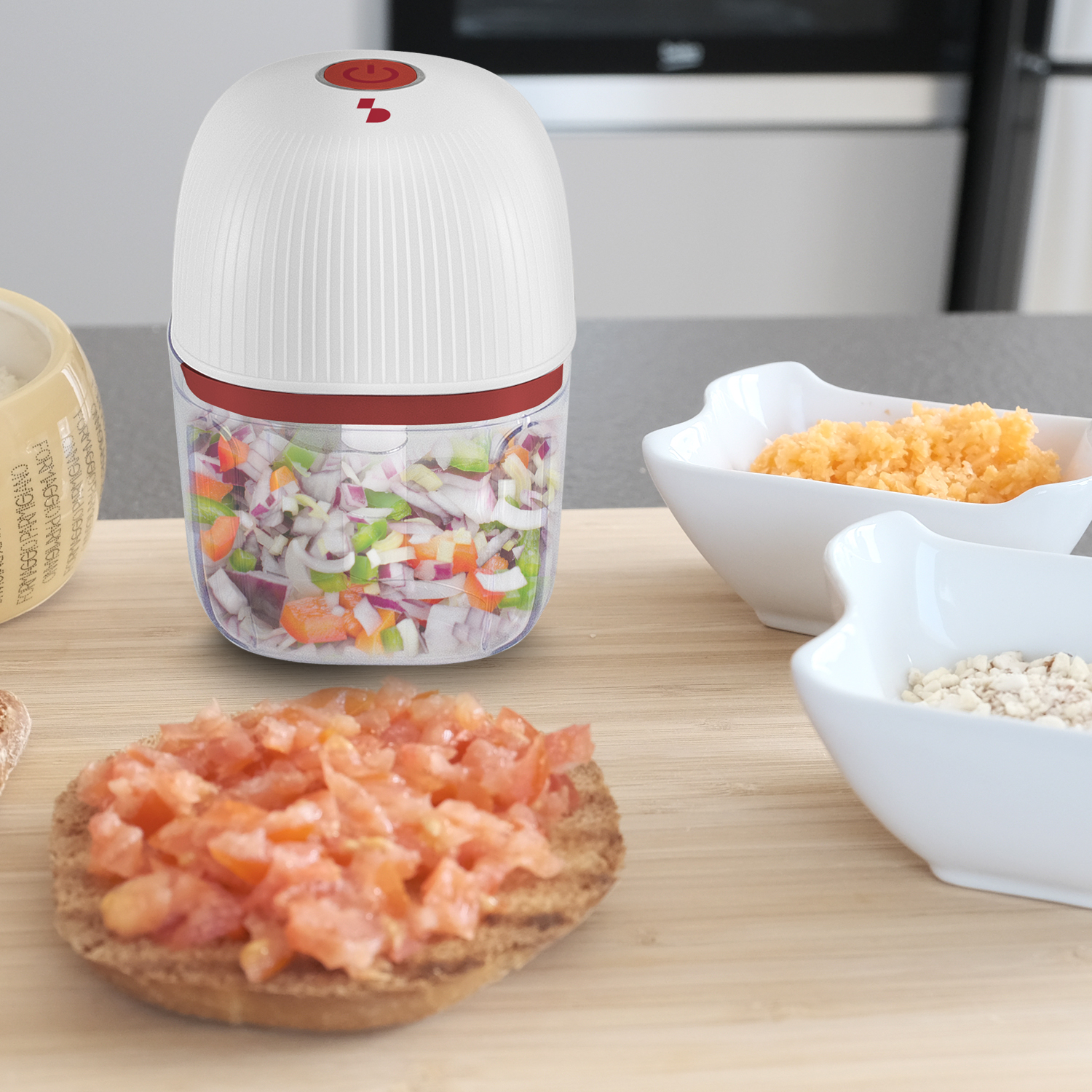 Un tritatutto bianco con pulsante rosso, pieno di verdure tritate.
