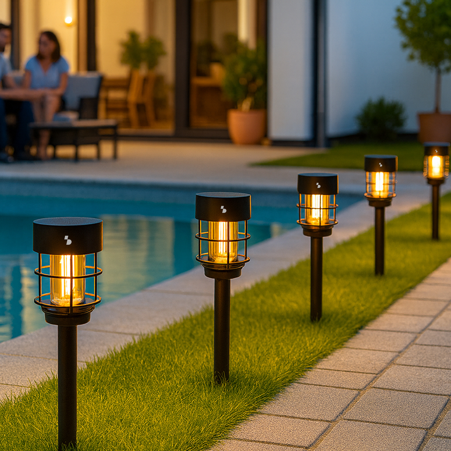 Fila di luci da giardino nere con lampadine luminose illuminano un percorso vicino a una piscina.