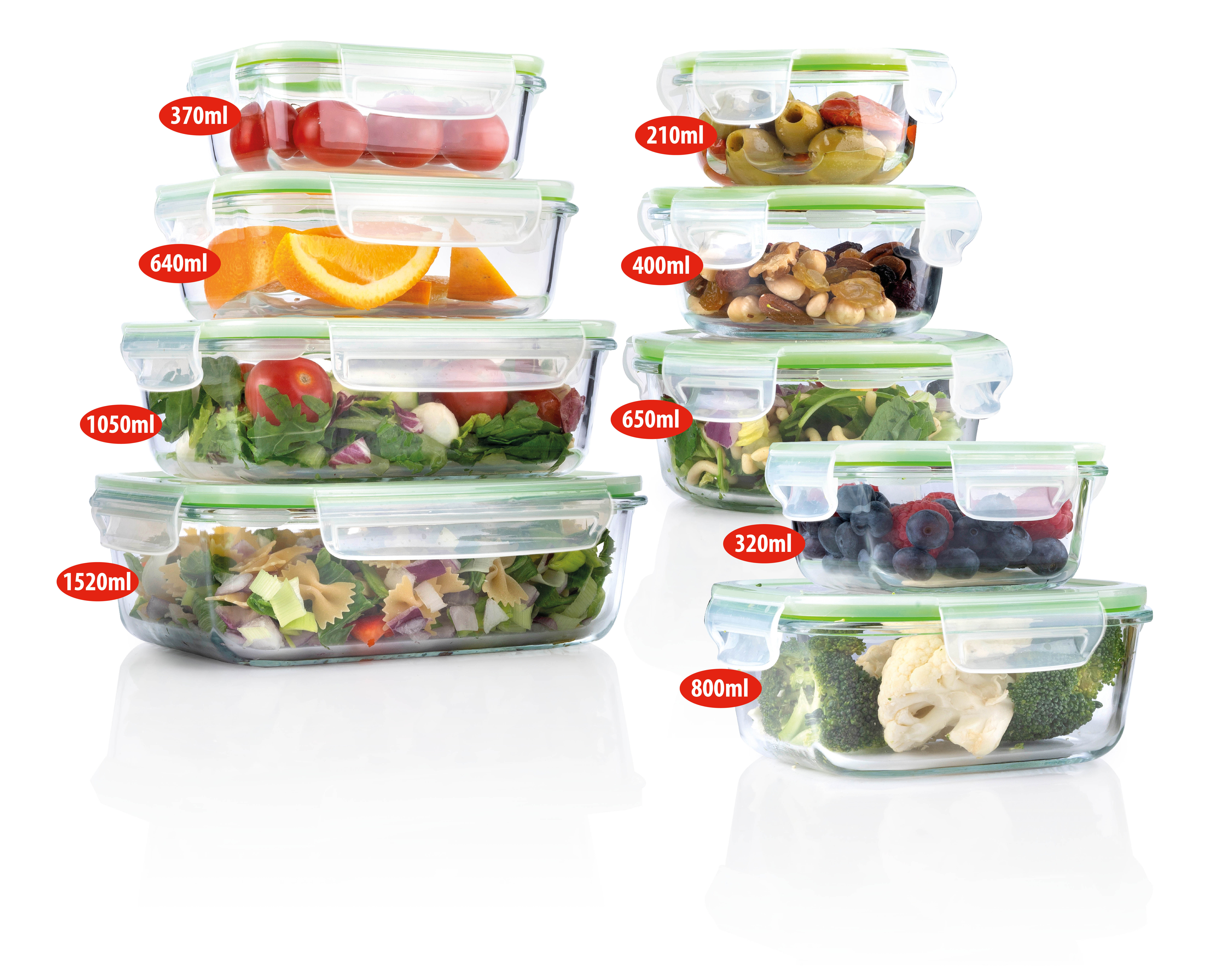 Several glass food containers with tomatoes, oranges, salads, nuts, berries, broccoli, and cauliflower.