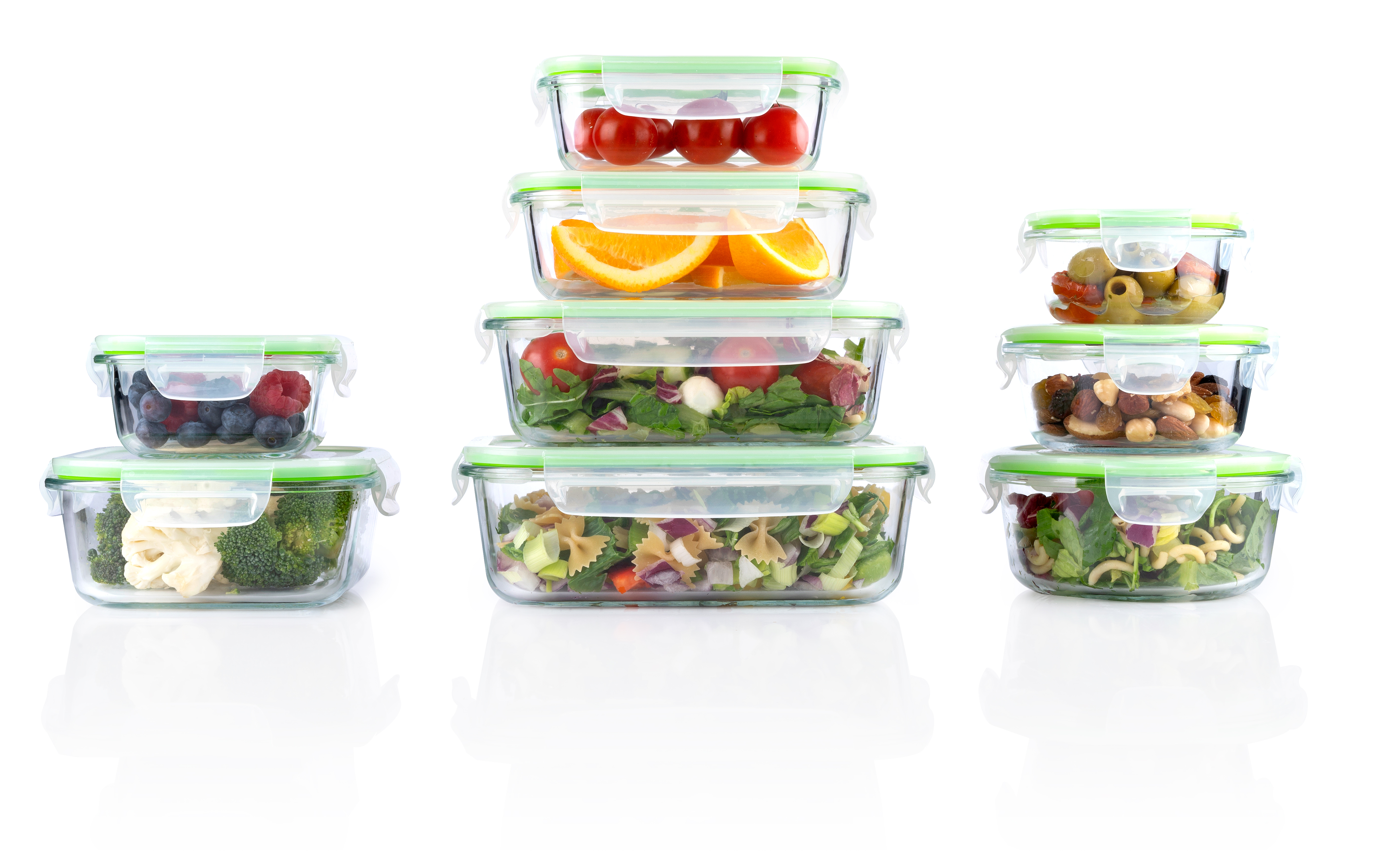 Stacked glass containers with food: berries, oranges, salads, nuts, and vegetables.