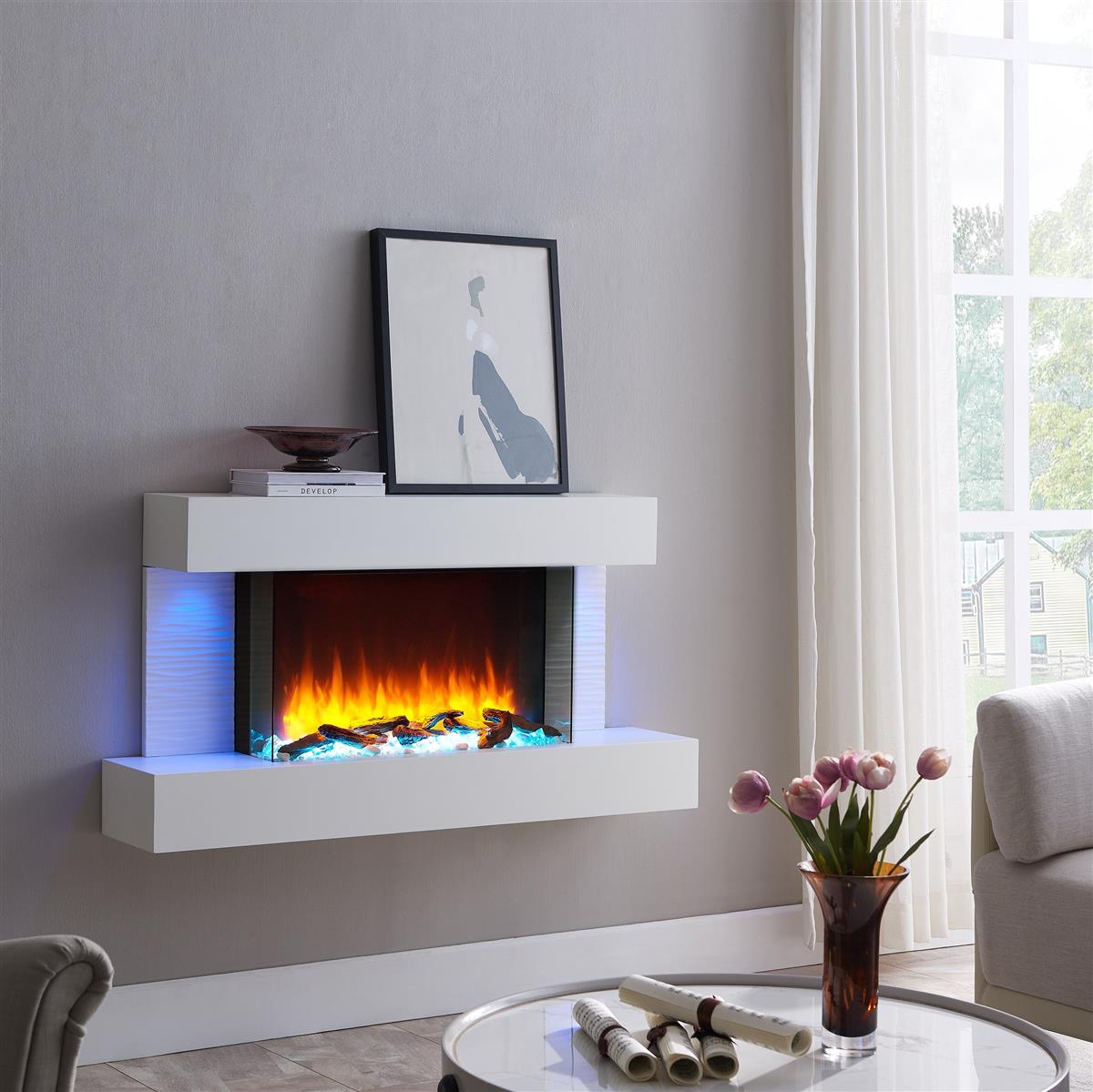 Moderner weißer Elektrokamin mit Flammen und blauer Beleuchtung, daneben ein Tisch mit Blumen.
