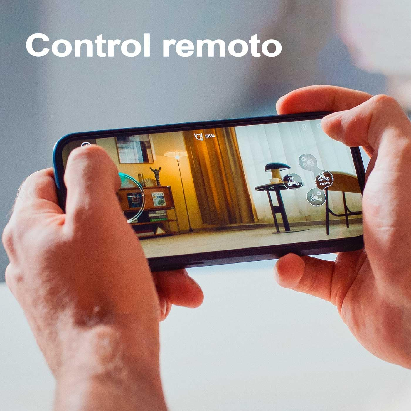 Manos sostienen un smartphone que muestra una app de control remoto con captura de sala.