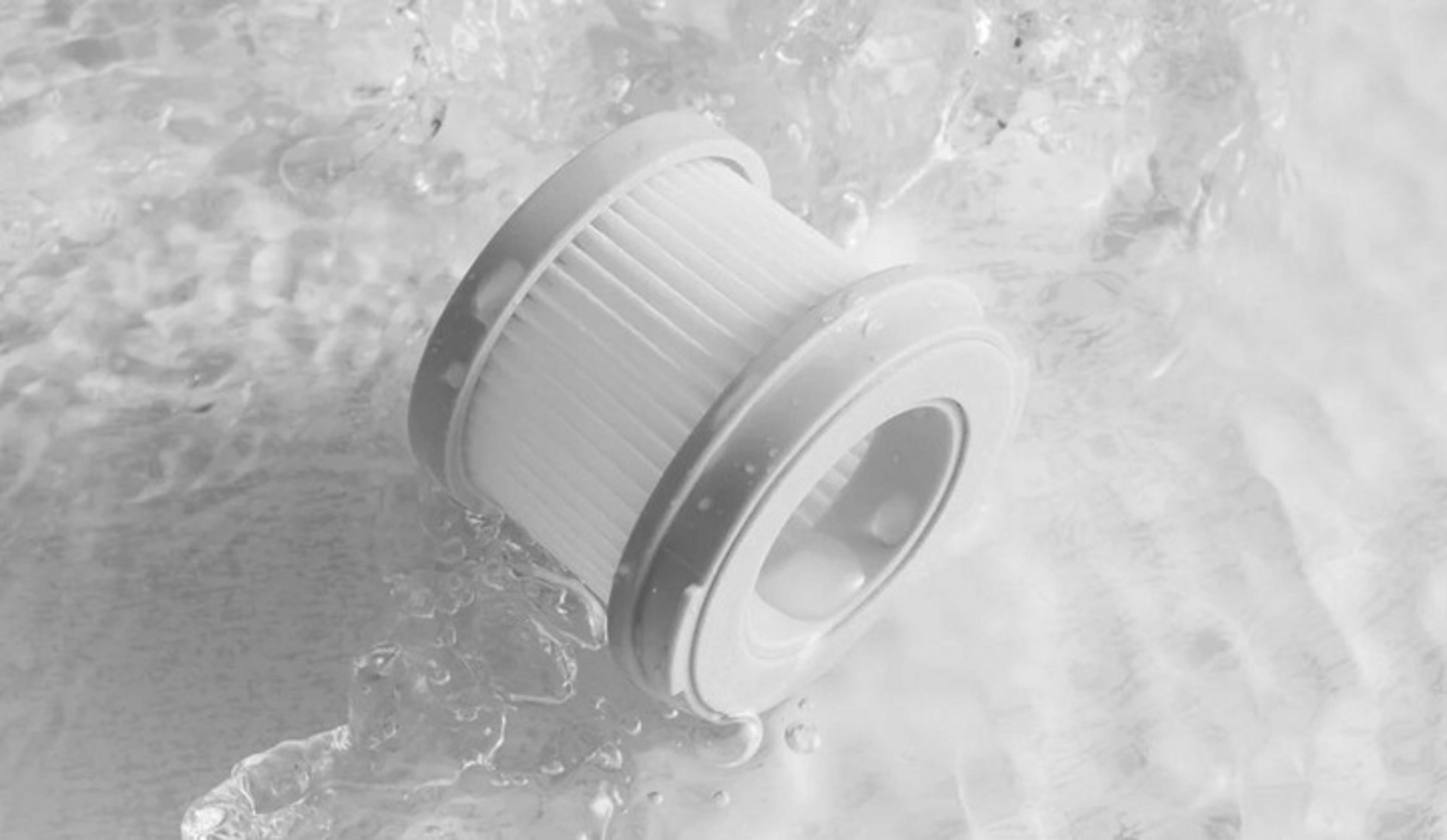 Biały filtr leży w bulgoczącej wodzie, zbliżenie.