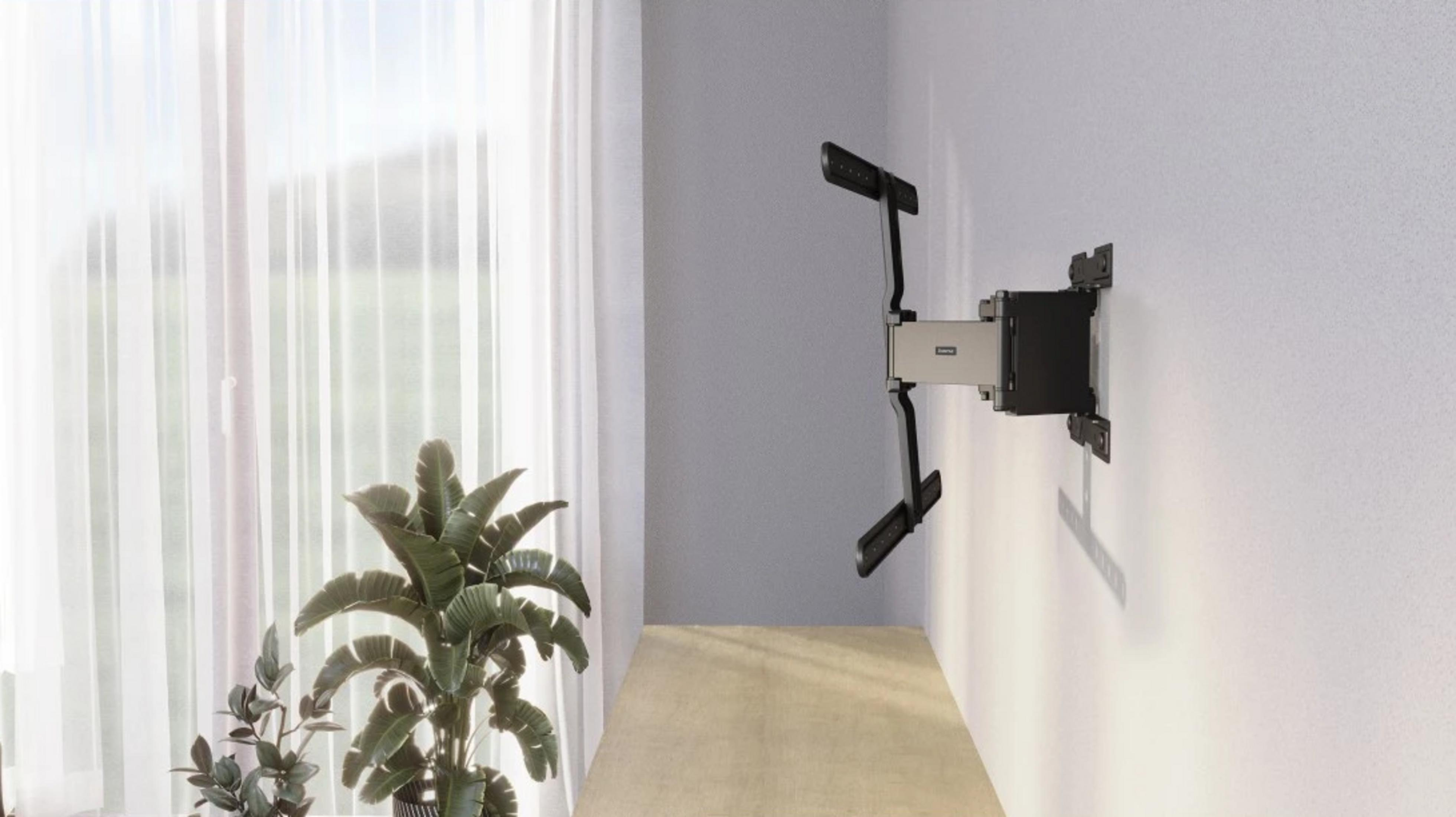 Czarno-srebrny uchwyt ścienny TV jest zamontowany na białej ścianie.