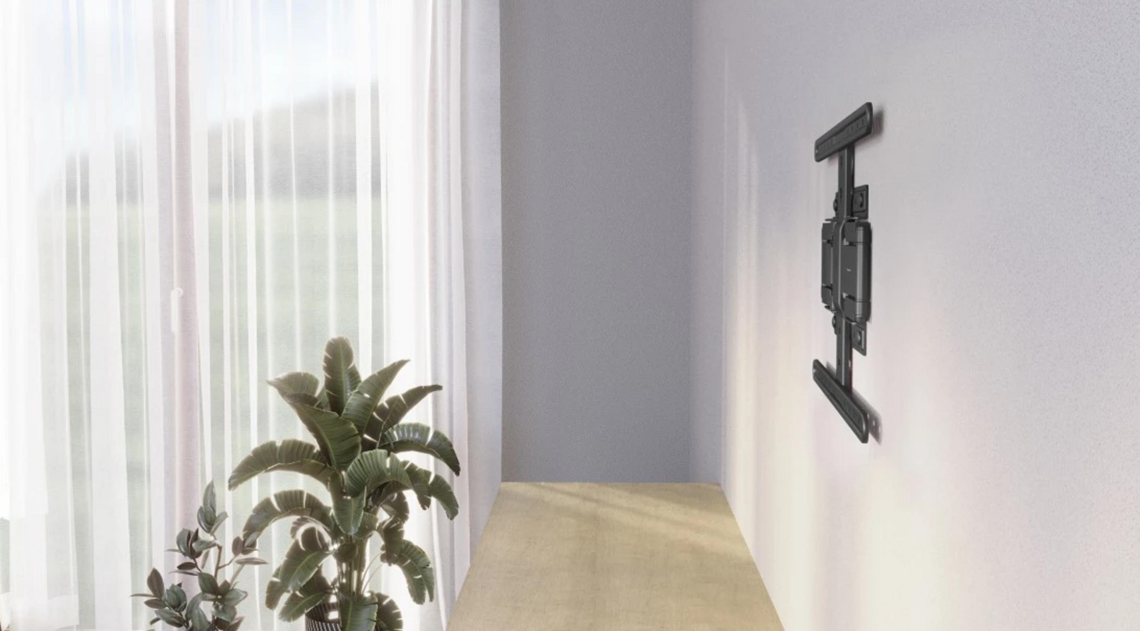 Czarny uchwyt ścienny do telewizora jest zamontowany na białej ścianie.