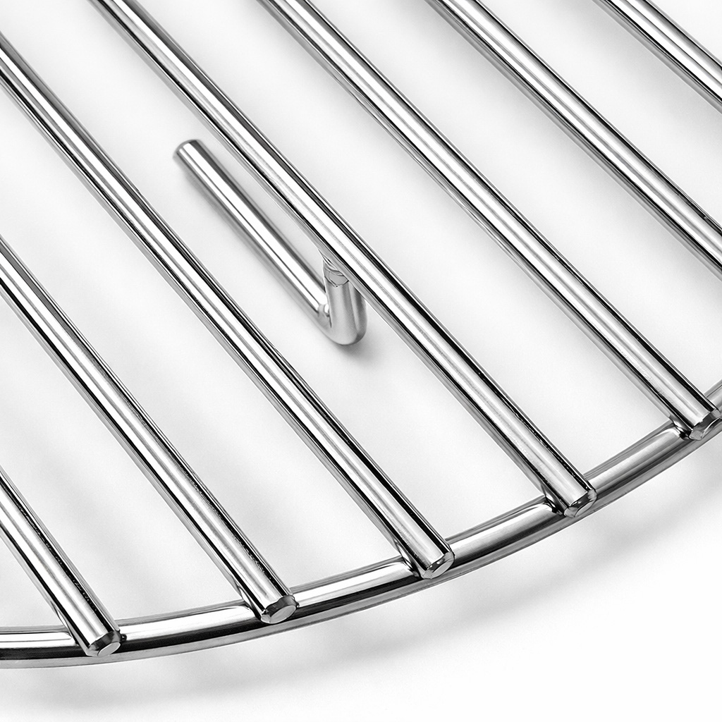 Close-up van een ronde, glanzende metalen grillrooster met parallelle staven.