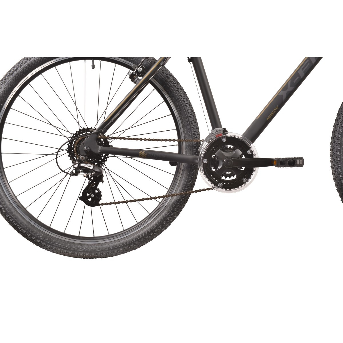 Zbliżenie na łańcuch i tylne koło czarnego roweru ze złotymi napisami.