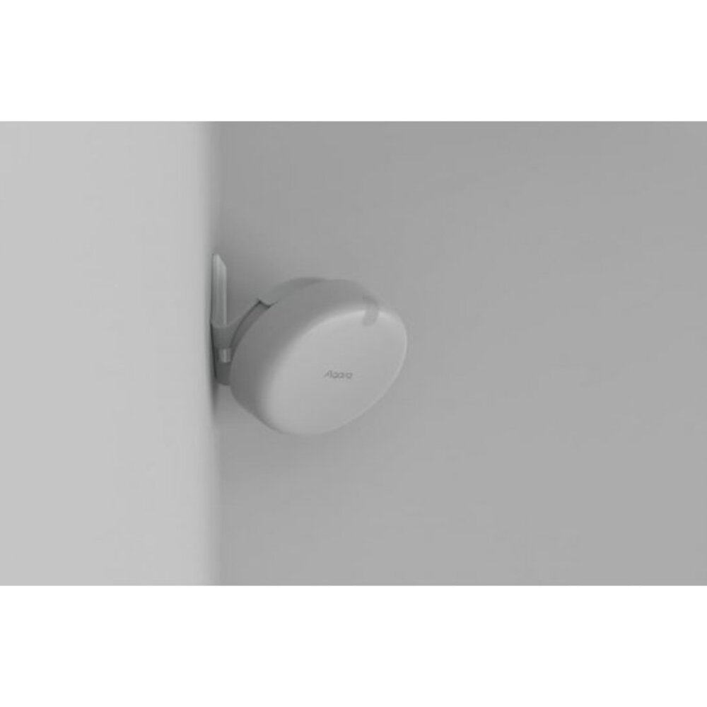 Ein weißer, runder Sensor mit Antenne ist an einer Wand montiert.