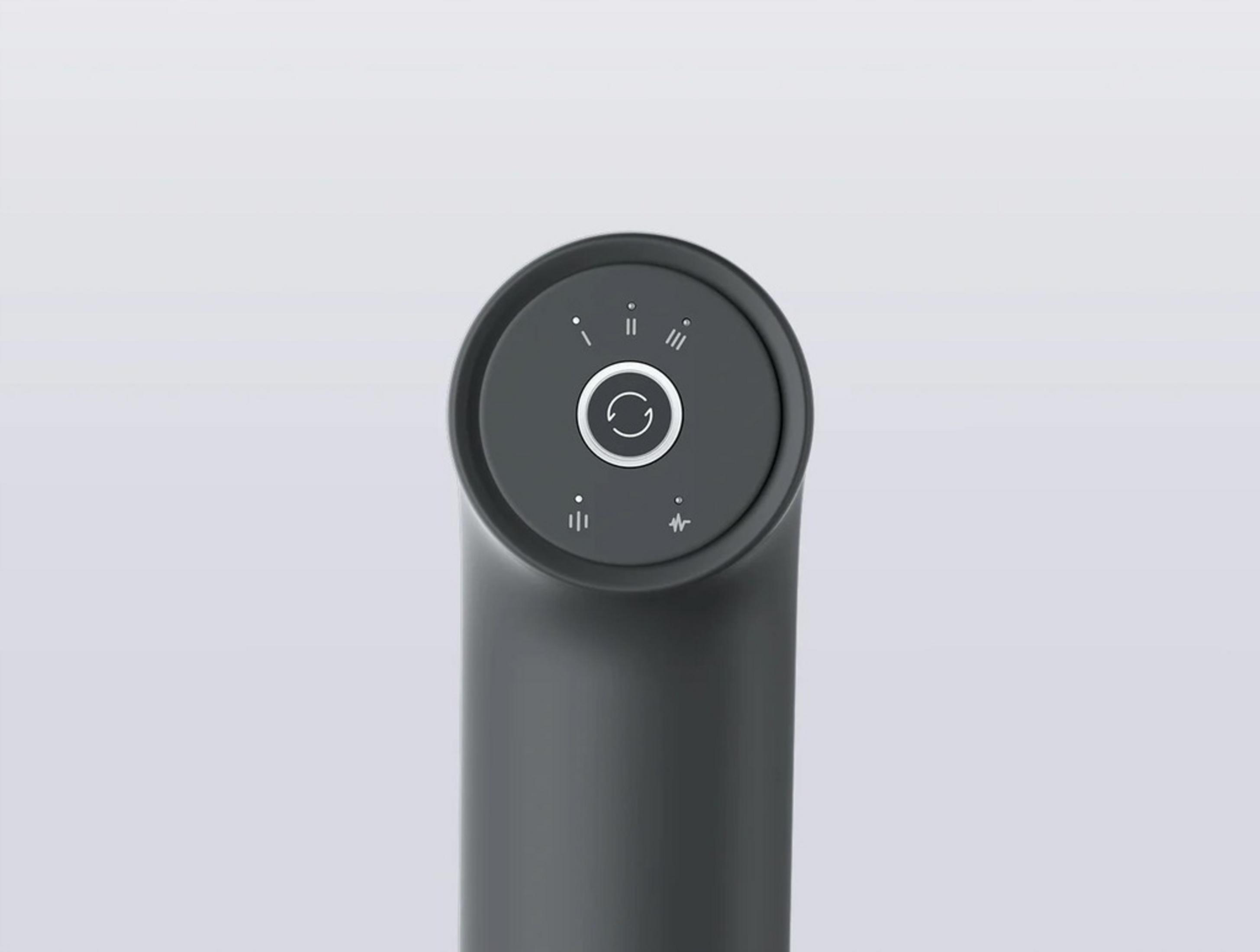 Ciemnoszary pistolet do masażu z okrągłym przyciskiem zasilania i wskaźnikami prędkości.