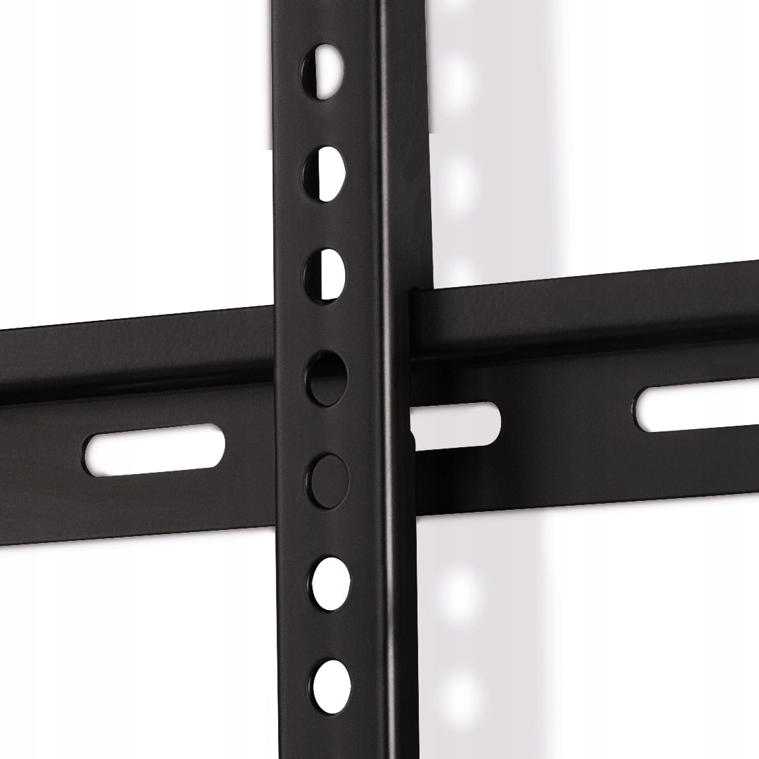 Zbliżenie czarnego metalowego wspornika z otworami i szczelinami.