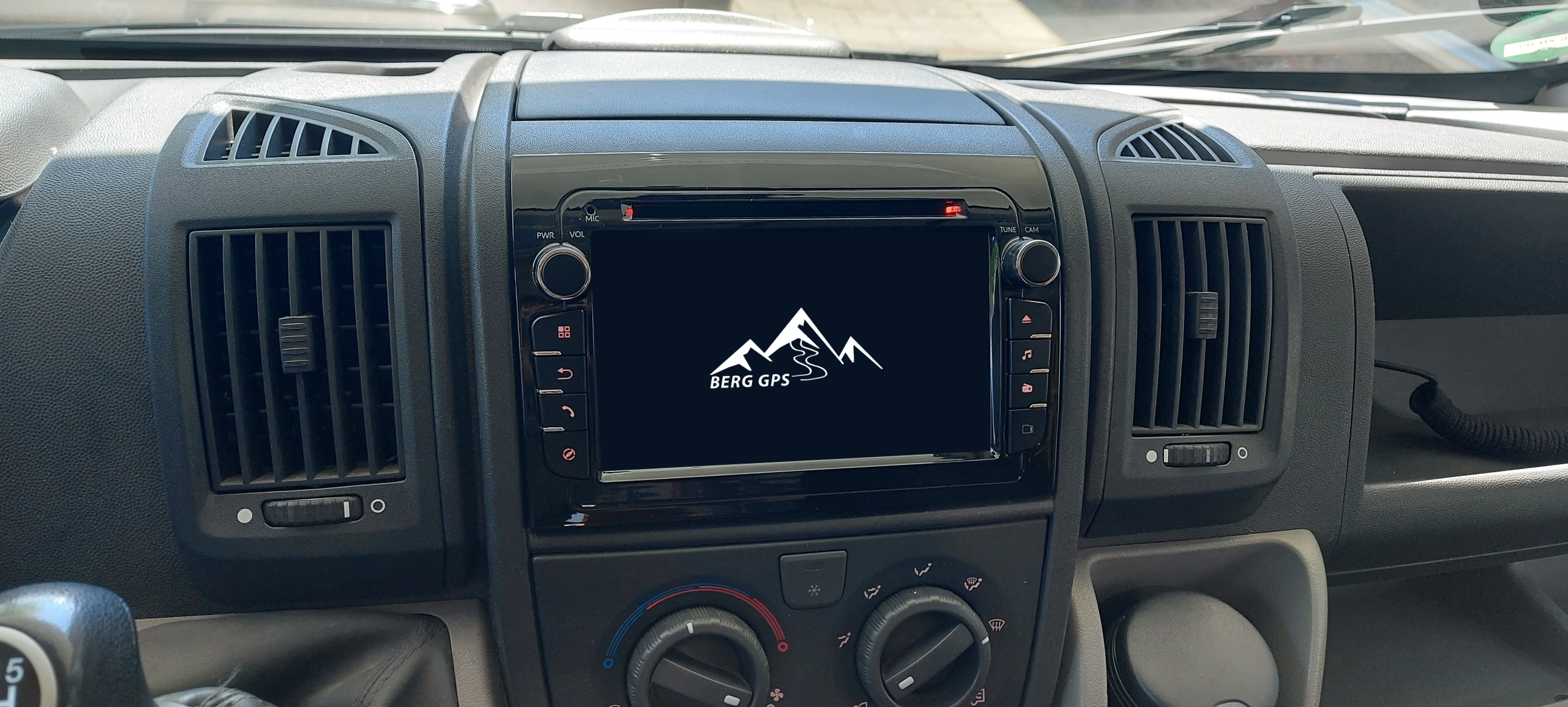 A vehicle's dashboard featuring an infotainment screen displaying a mountain logo.