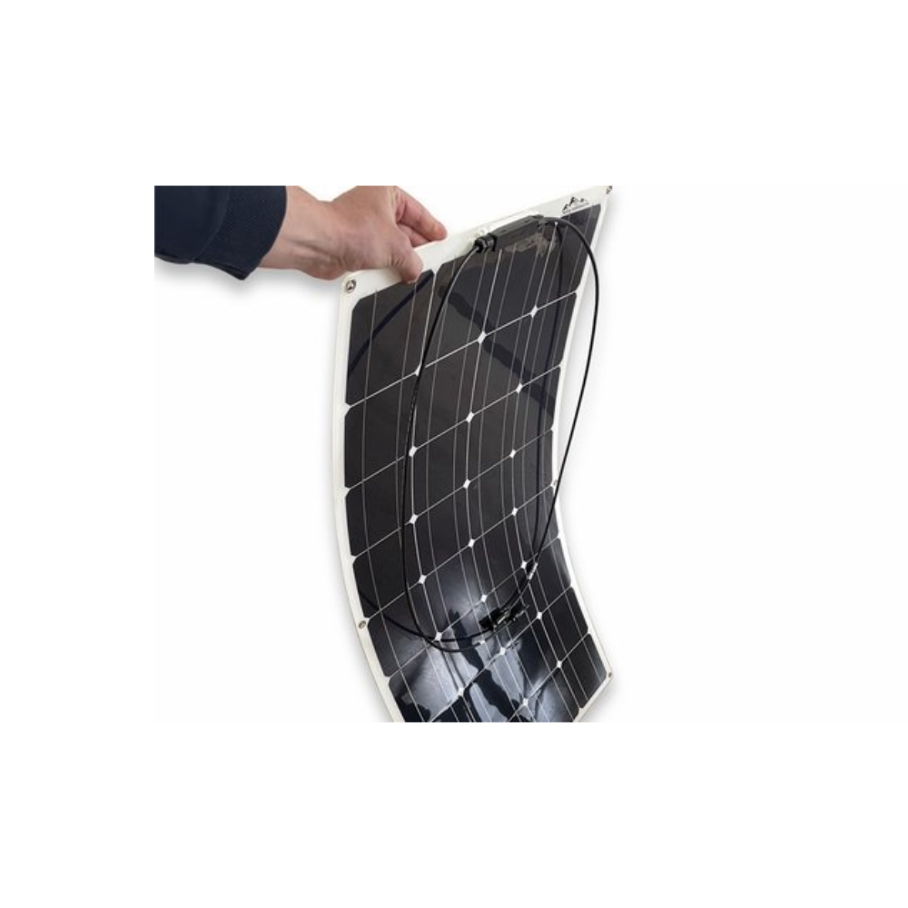 A hand holding a flexible black solar panel with white edges.