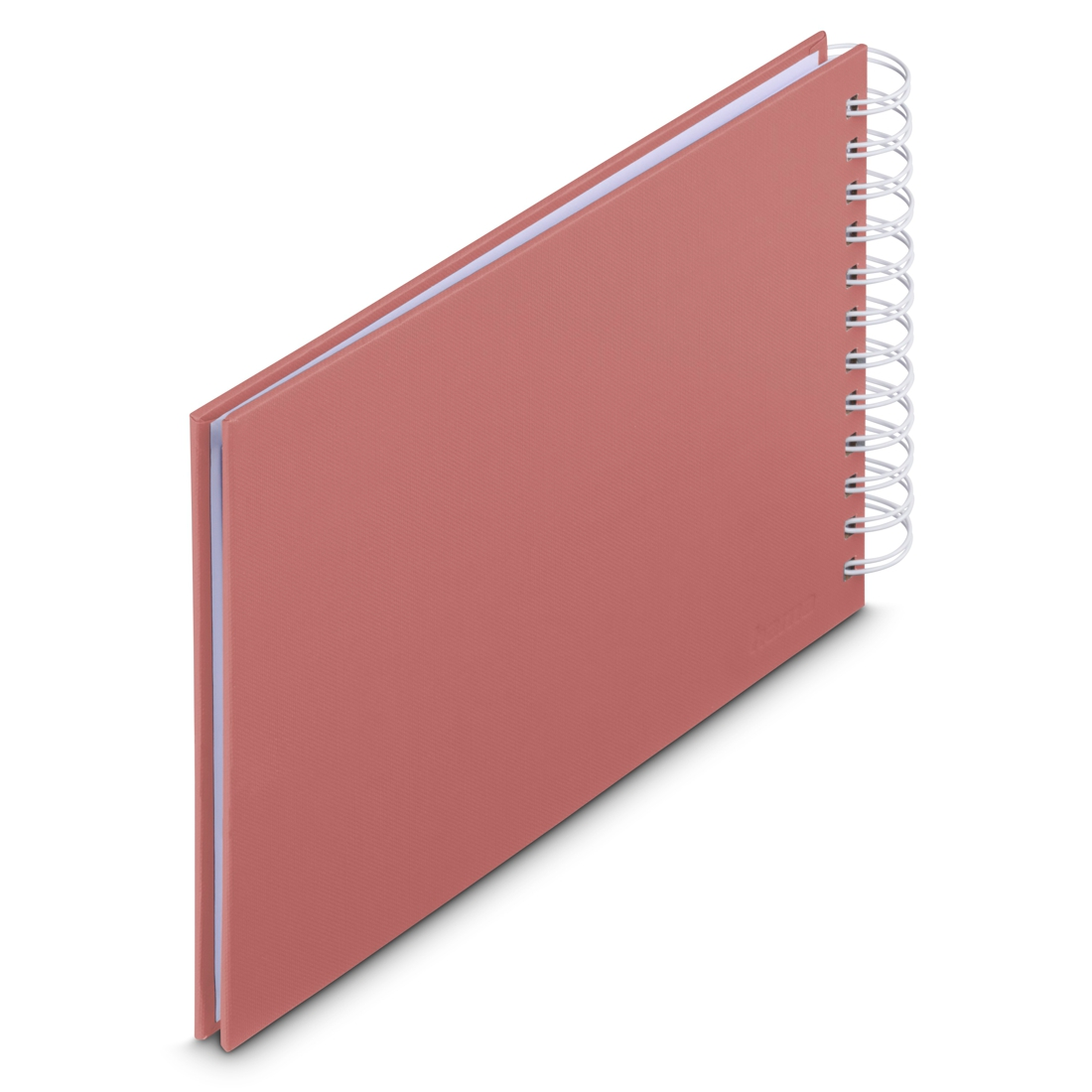 Koralowy notatnik bindowany spiralą leży na białej powierzchni.