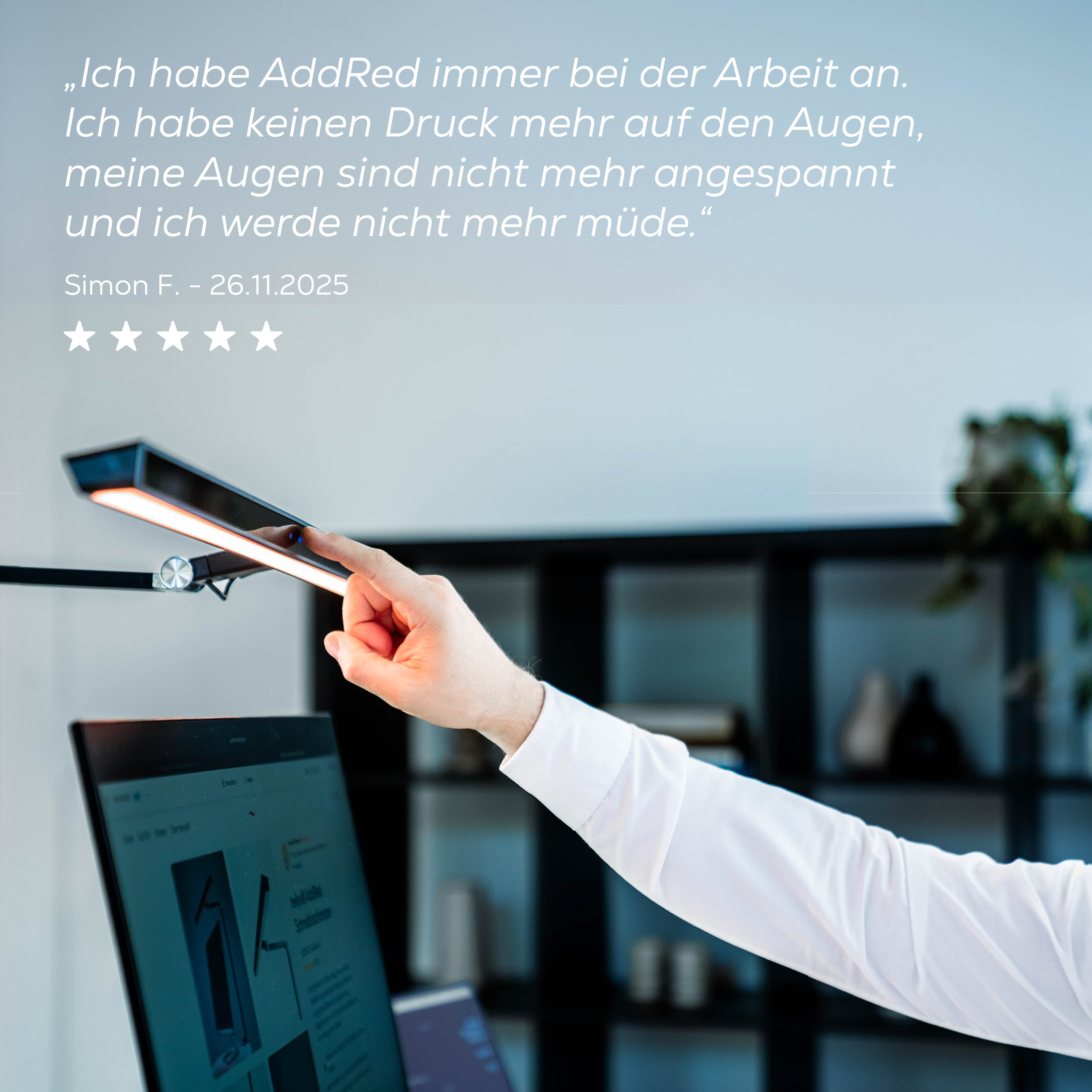 Ein Mann berührt eine helle Schreibtischlampe über einem Laptop. Es gibt eine Bewertung.