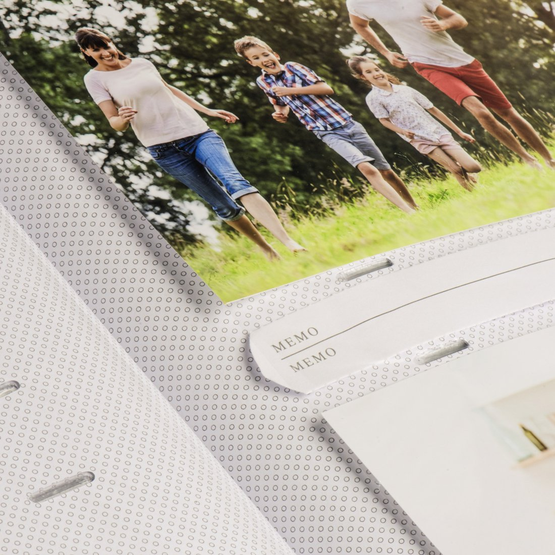 Rodzina biegnie boso po zielonej łące na zewnątrz.