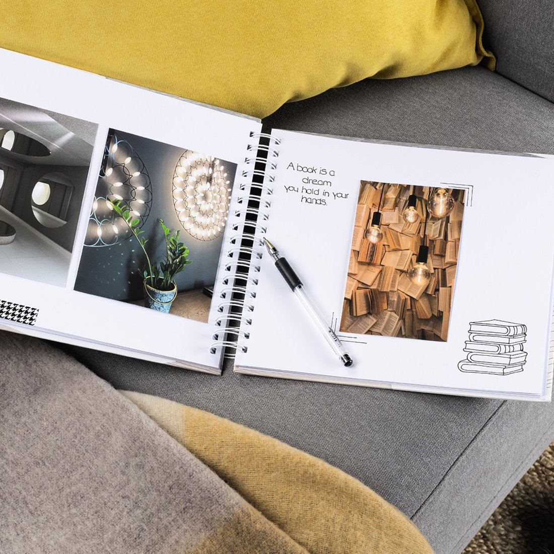Otwarty album ze zdjęciami architektury, świateł i książek. Leży na nim długopis.