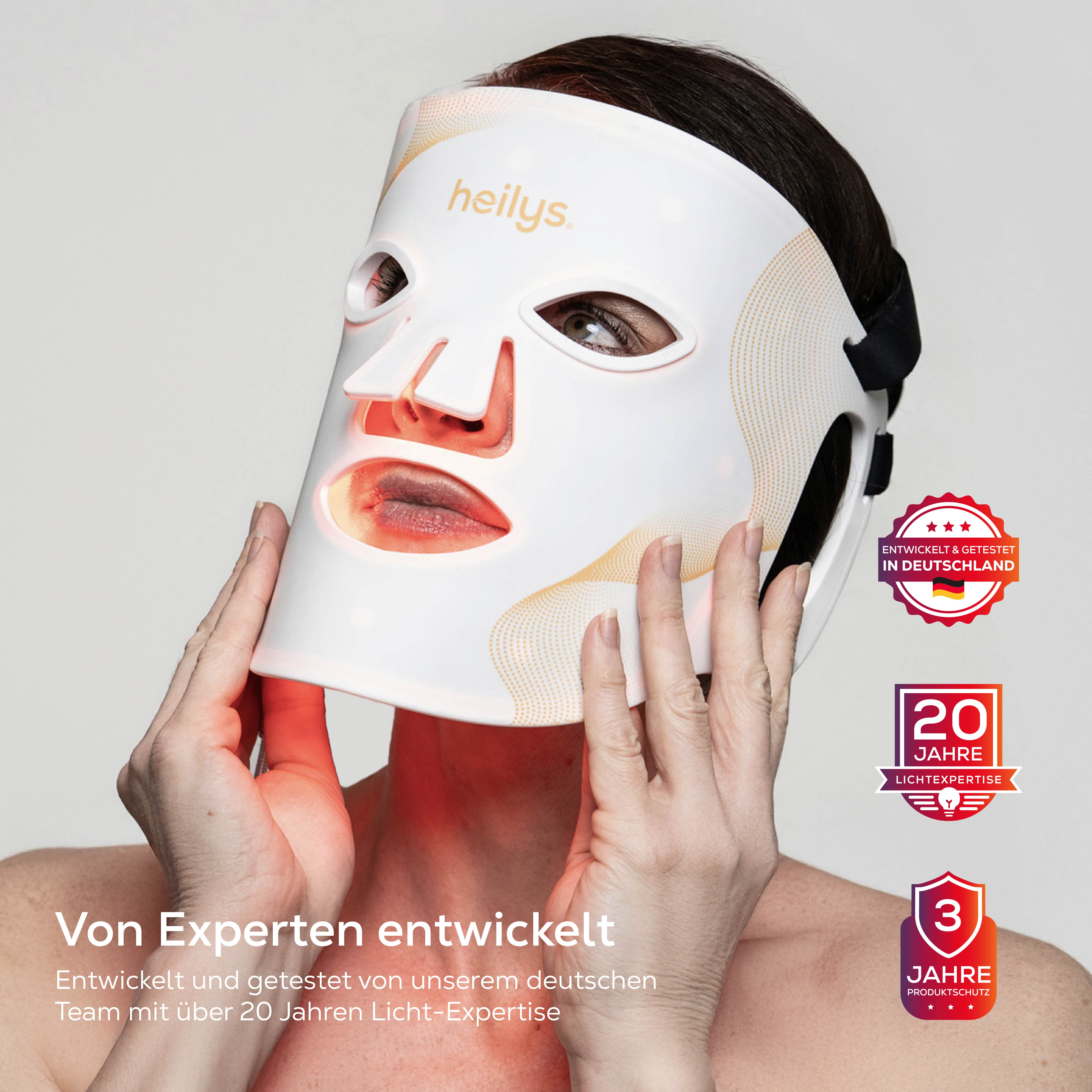 Eine Frau trägt eine weiße Heilys-Maske mit rotem Licht. Siegel zeigen 20 Jahre Lichtexpertise.