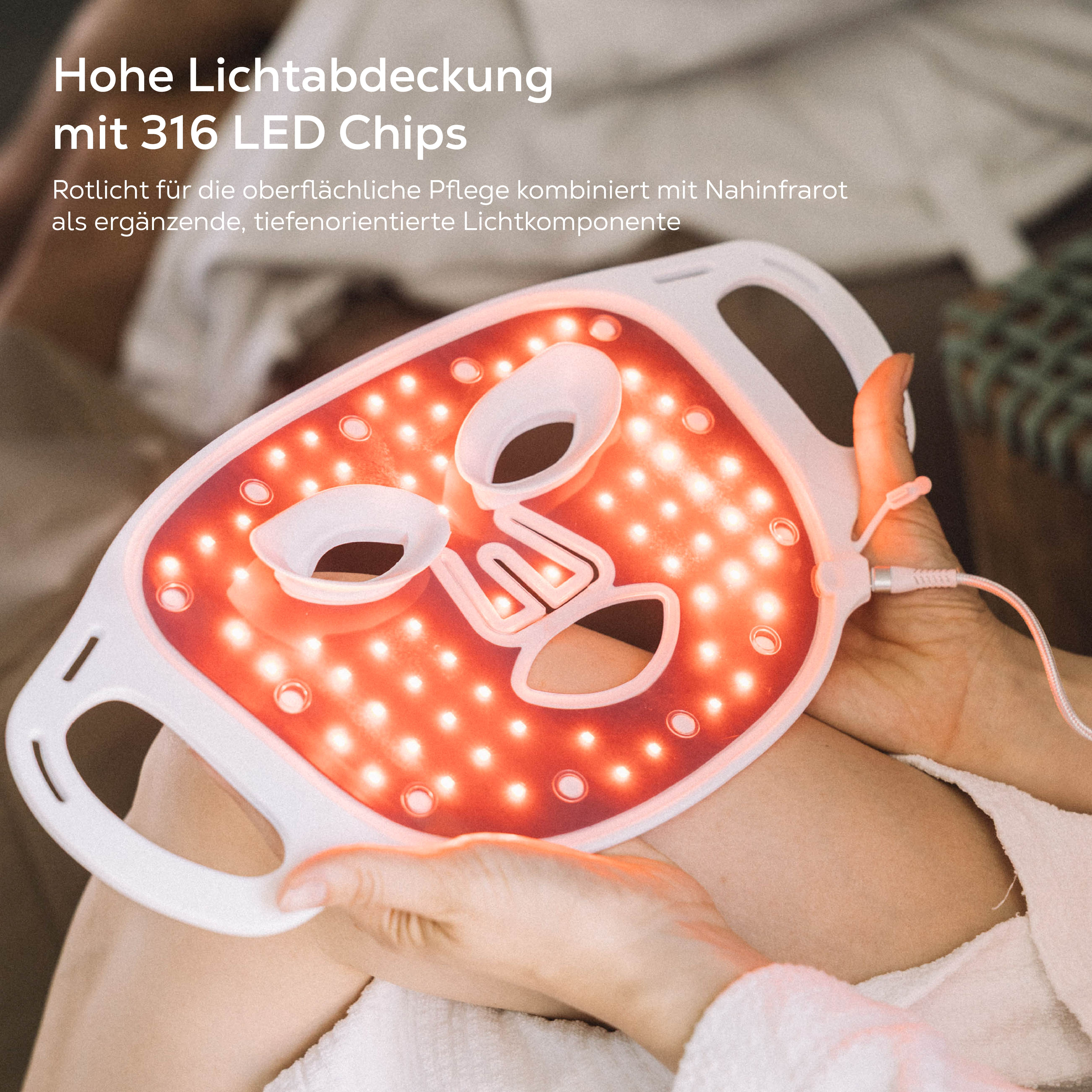 Eine weiße LED-Gesichtsmaske mit roten Lichtern, die eine Person hält.