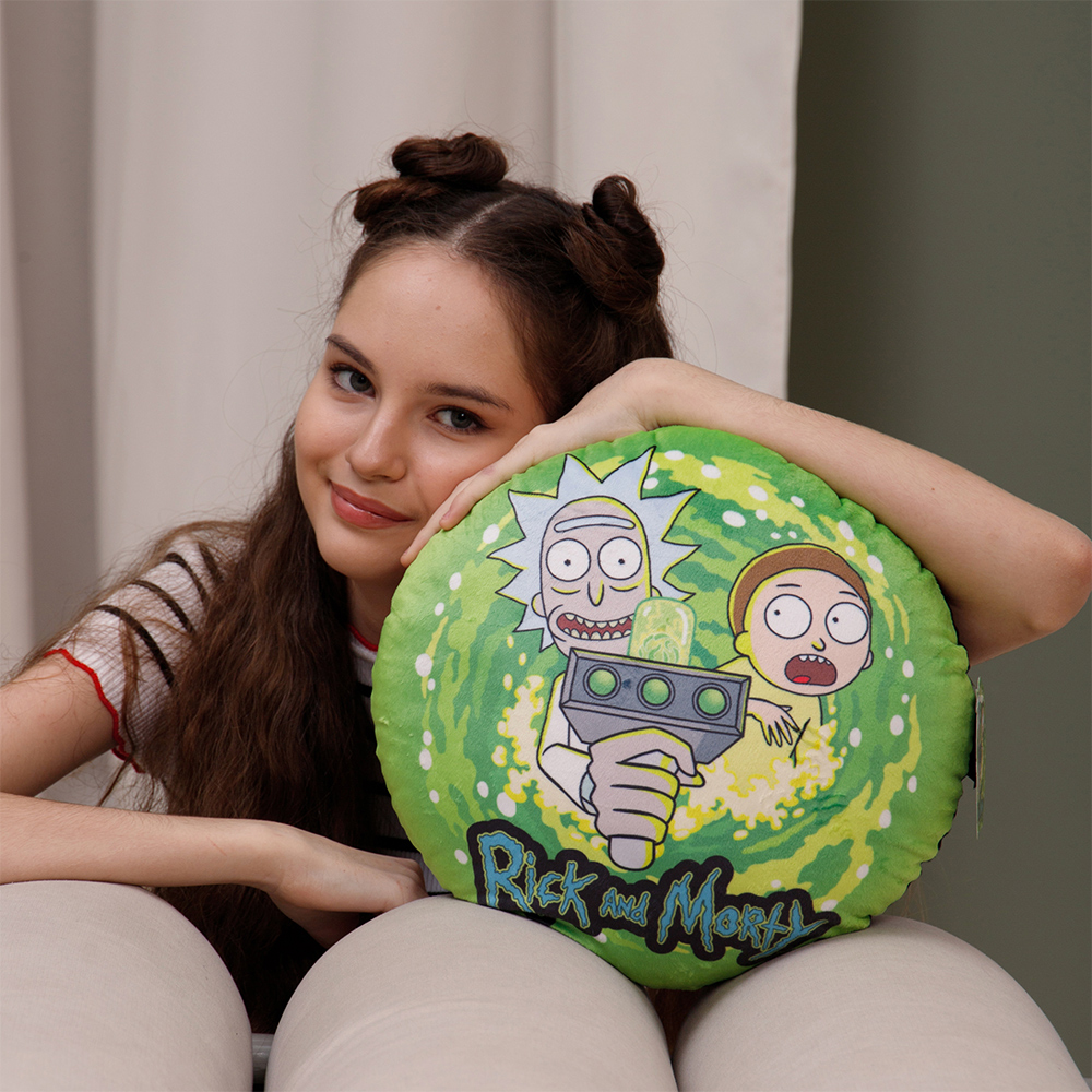 Una ragazza con due chignon tiene un cuscino di Rick e Morty.