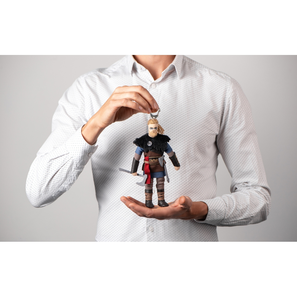 Un uomo tiene una statuetta vichinga con asce tra le mani.