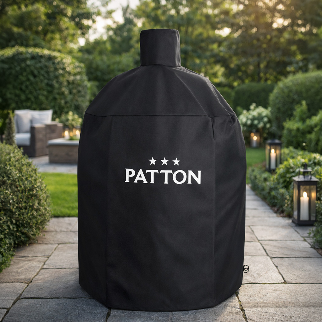 Black grill cover with PATTON logo on a paved garden path.