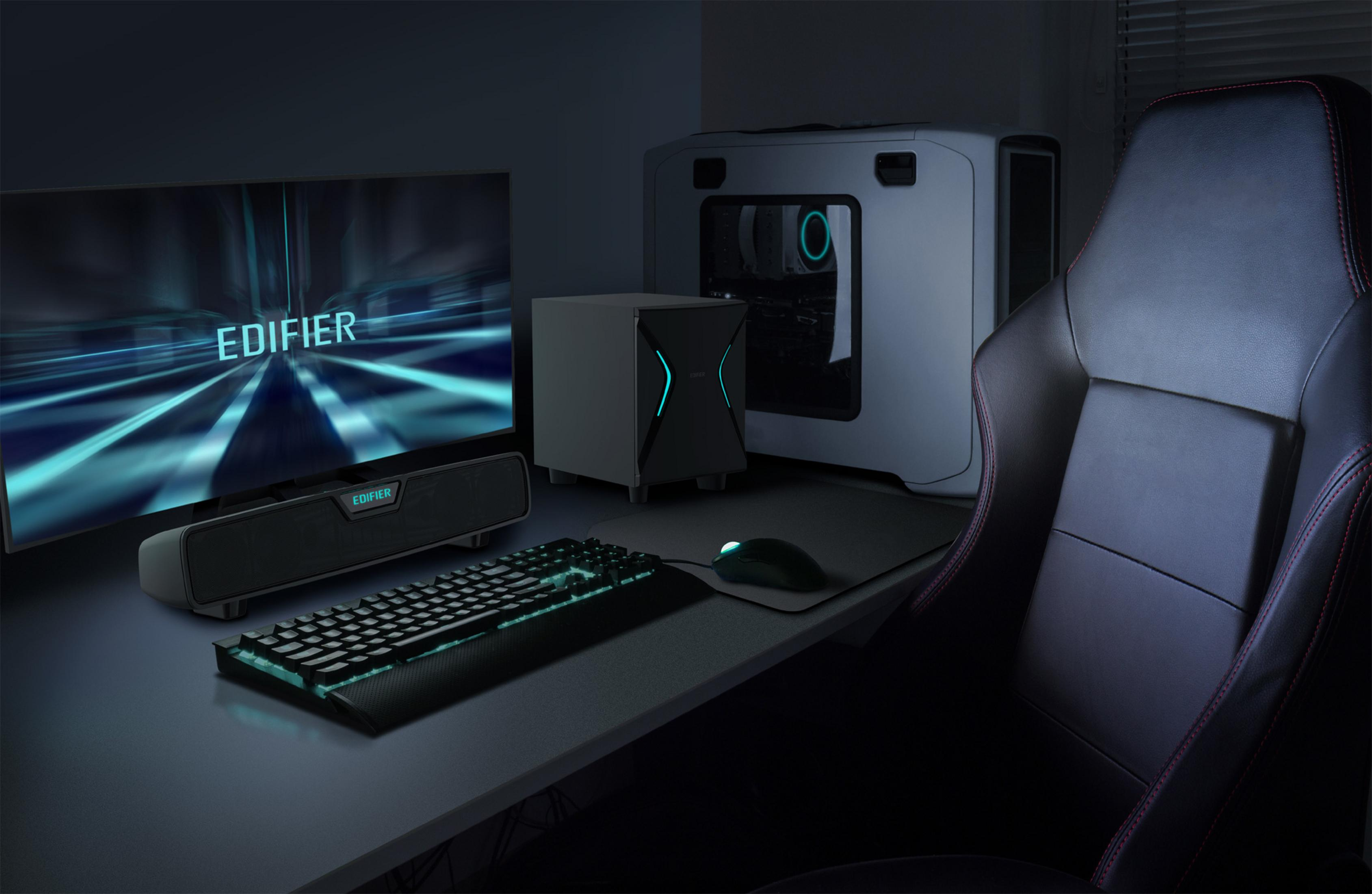 Una configuración de juego con monitor, teclado, ratón, altavoces, PC y silla.