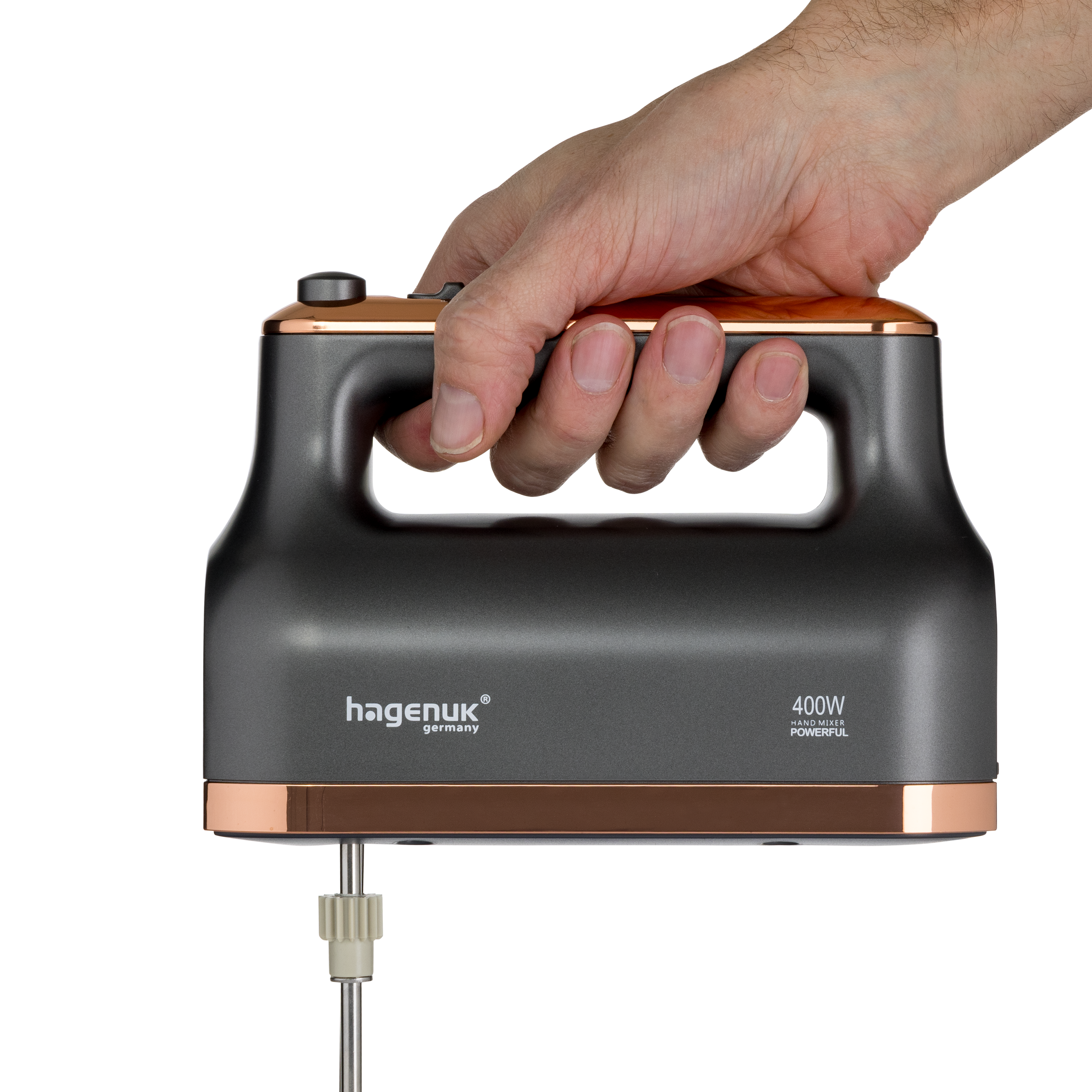 Hand hält einen grauen Handmixer mit Kupferakzenten und einem Schlagbesen.