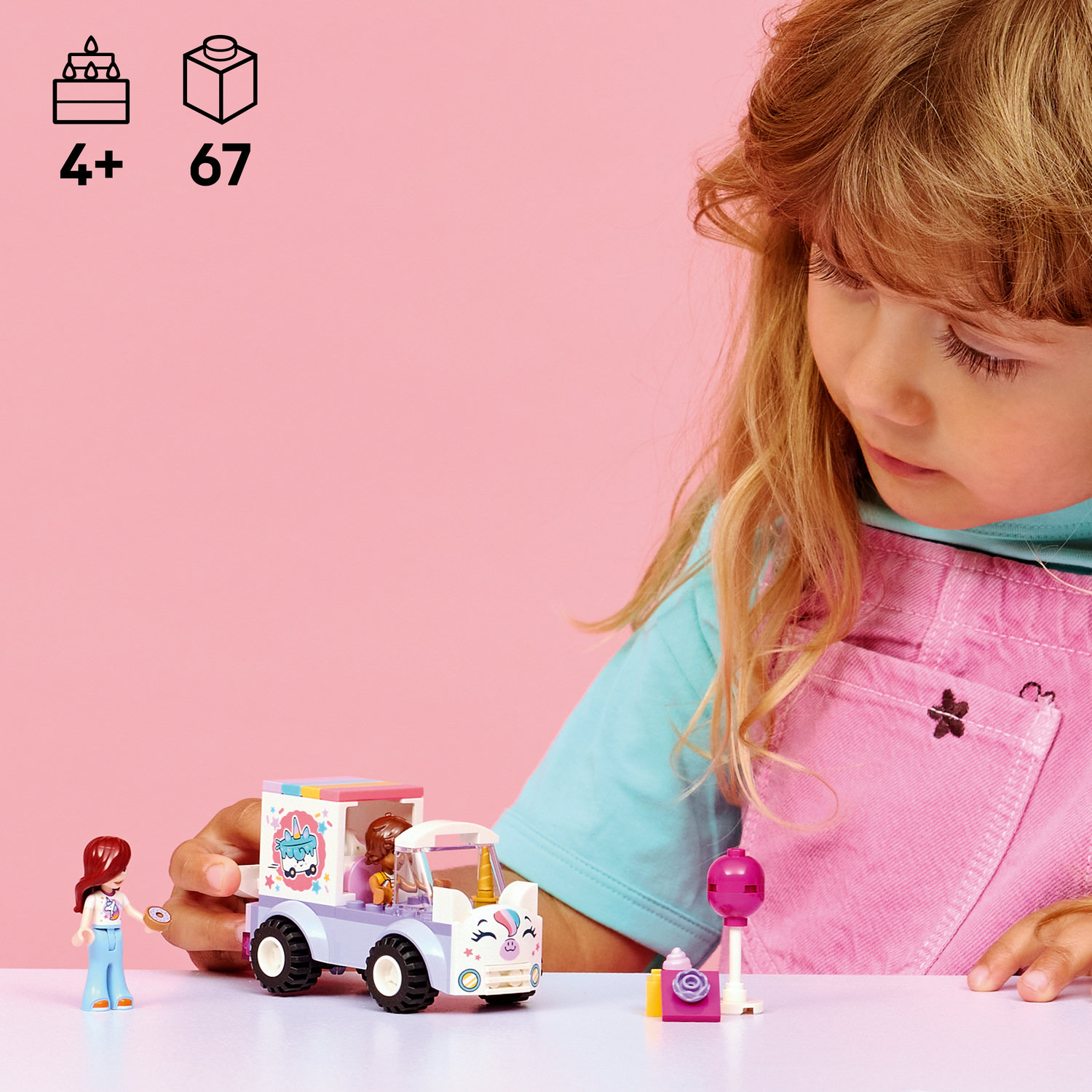 Ein Mädchen spielt mit Lego: eine Eiswagenfigur, eine Figur und ein Lollipop.