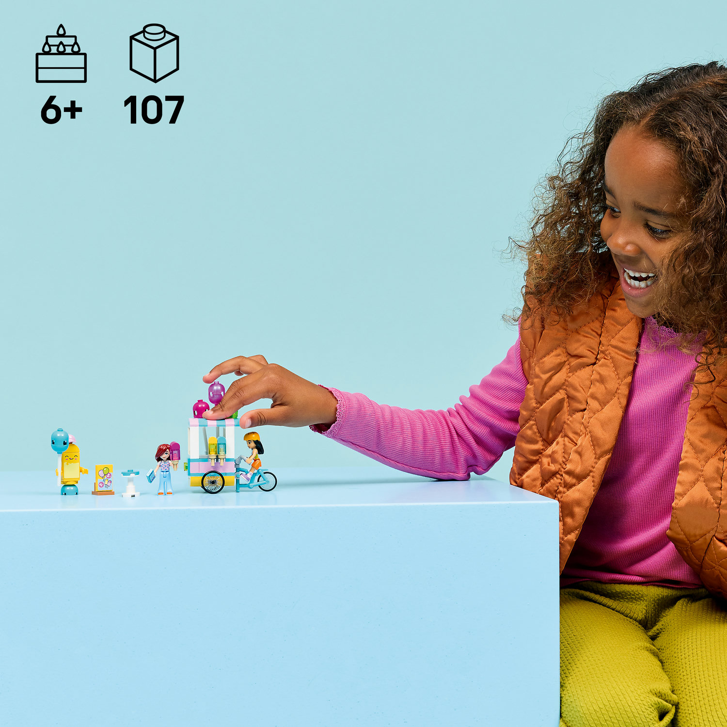 Kız, renkli Lego tuğlalarıyla oynuyor.