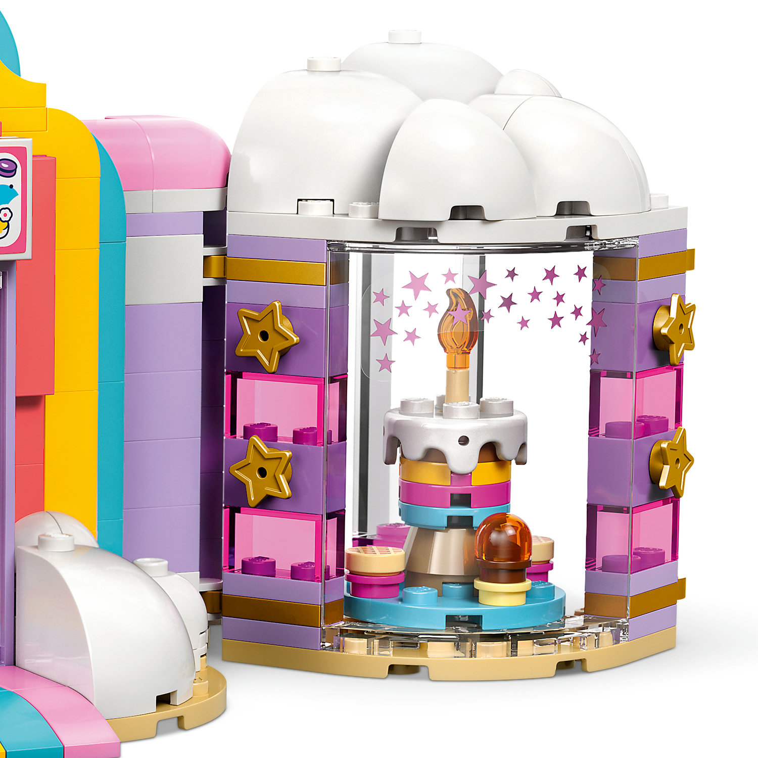 Kolorowy budynek Lego z dekoracją tortu w środku, oświetlony płomieniem świecy.