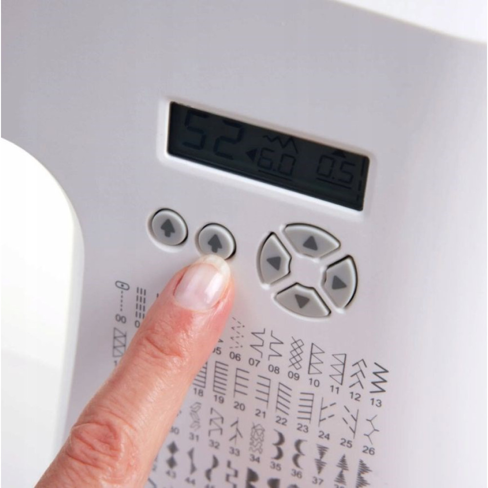 Palec naciska przycisk na maszynie do szycia z cyfrowym wyświetlaczem.