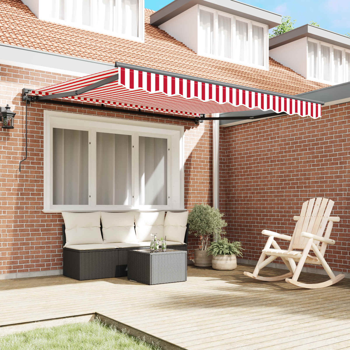 Eine Veranda mit rot-weißer Markise, Sofa, Tisch und Schaukelstuhl.