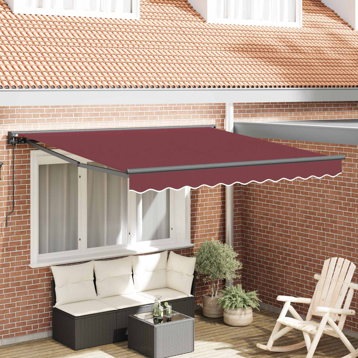 Eine burgunderrote Markise überspannt eine Terrasse mit Korbmöbeln und einem Schaukelstuhl.