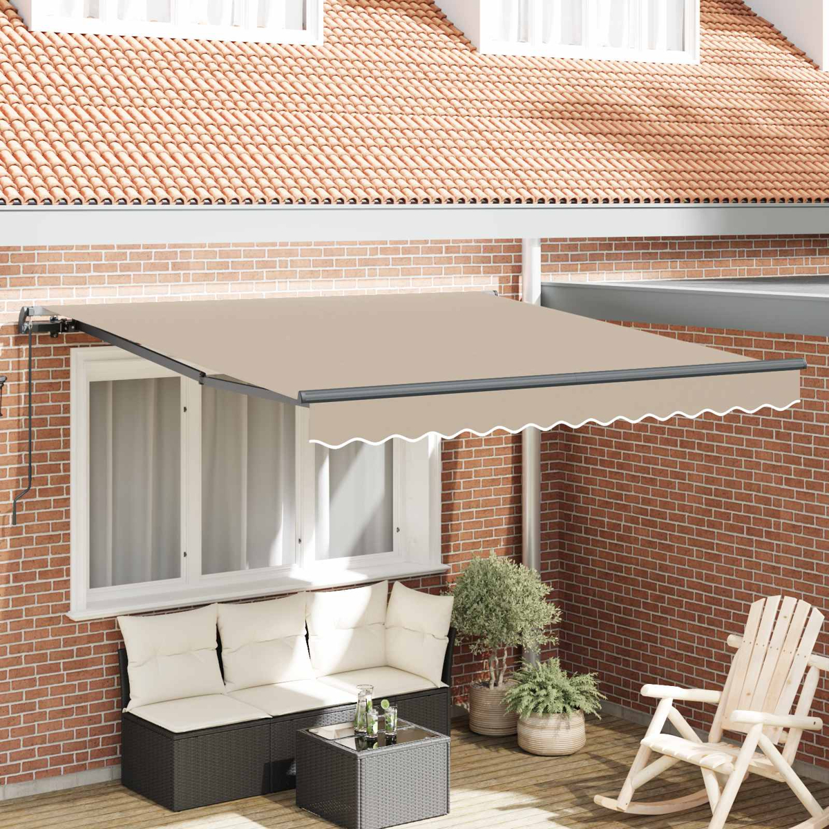 Una tenda da sole beige si estende su un patio con divano in vimini, tavolo di vetro e sedia a dondolo.