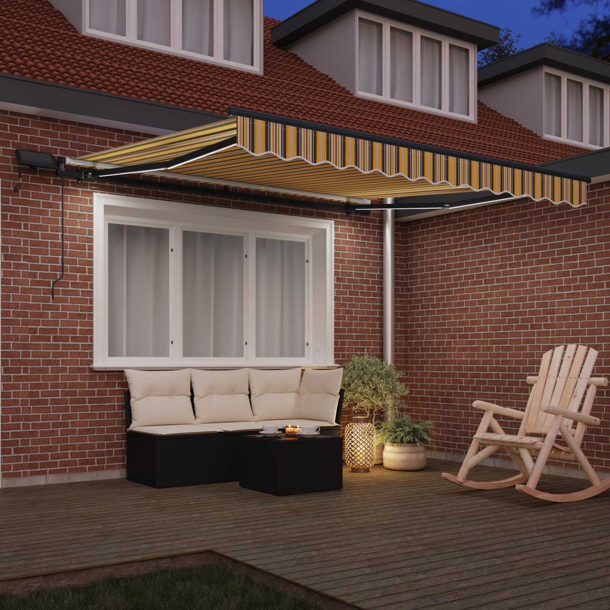 Terrasse mit Markise, Sitzgelegenheiten, Tisch, Schaukelstuhl und Pflanzen in der Dämmerung.