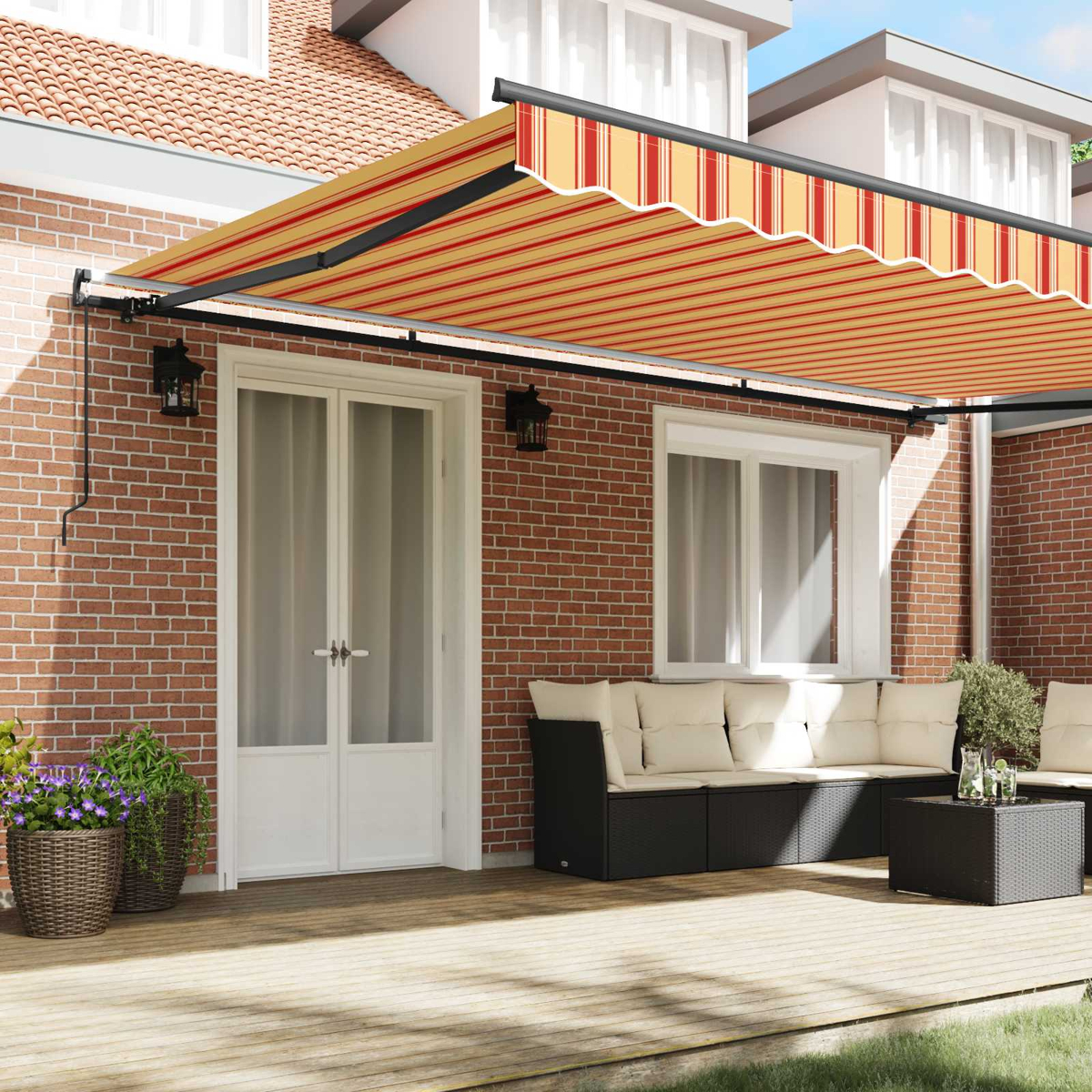 Una tenda da sole estesa a strisce rosse e gialle su un patio con mobili.